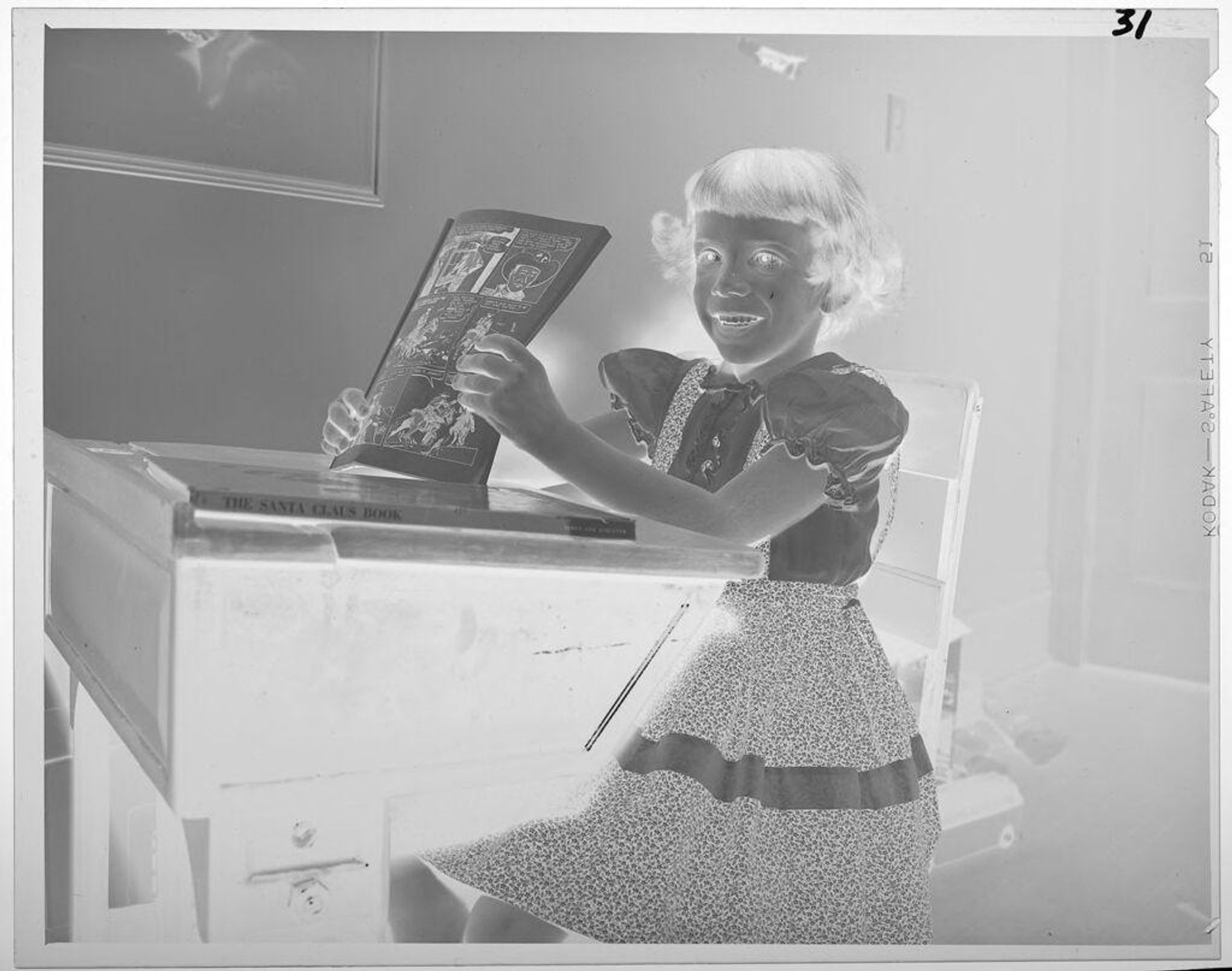 Untitled (girl sitting at school desk holding comic book) by Lucian and Mary Brown
