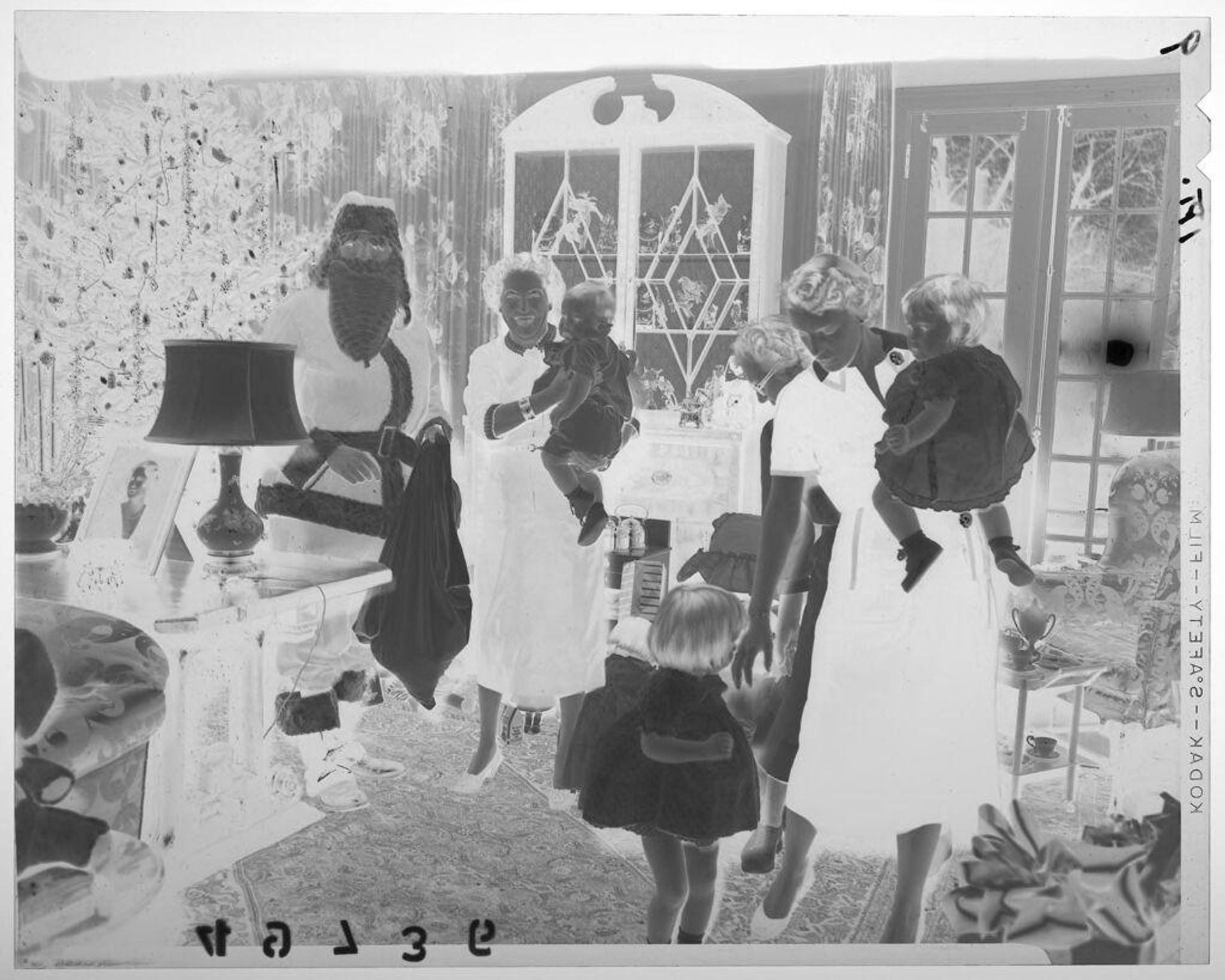 Untitled (family in Christmas living room with woman holding young boy and man in santa suit smiling for camera) by Martin Schweig