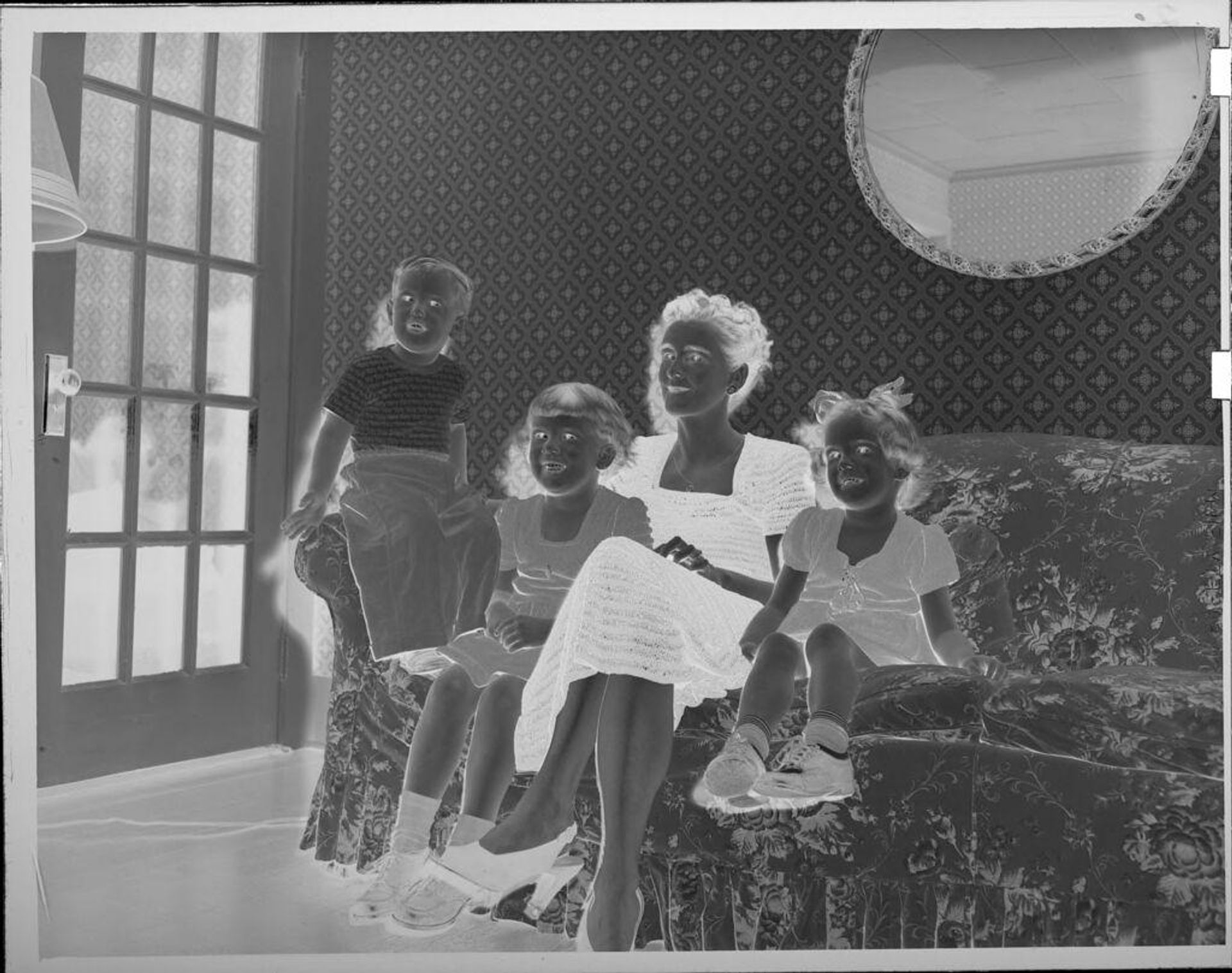 Untitled (woman and children on floral couch) by Lucian and Mary Brown