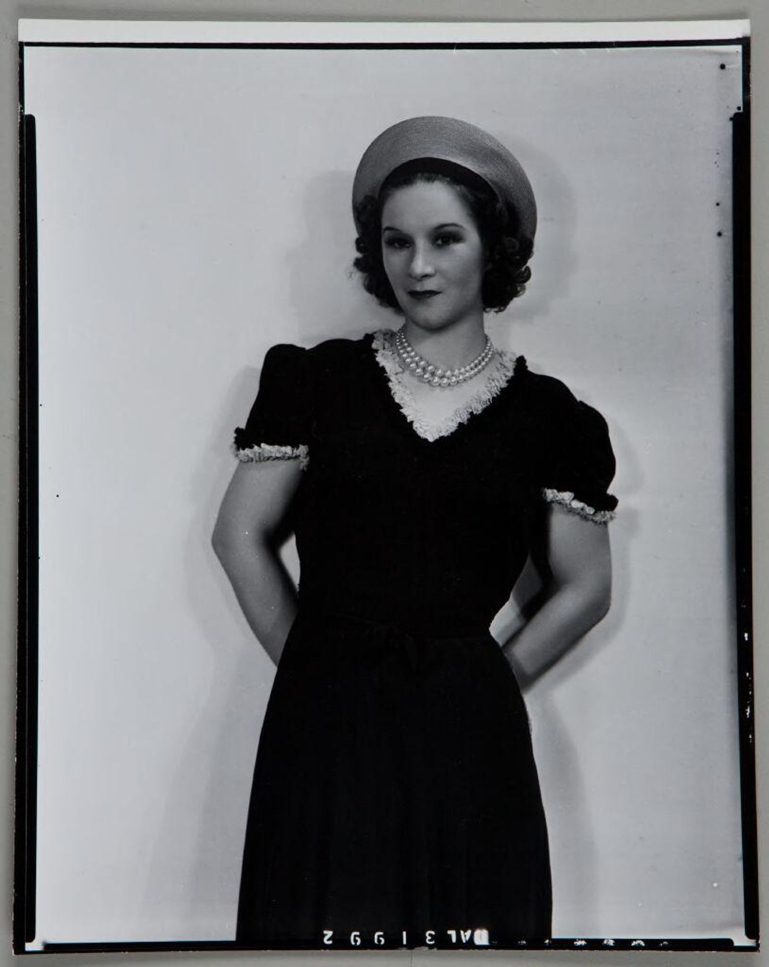 Untitled (portrait of woman in hat, pearls, and dress with ruffled trim) by Paul Gittings