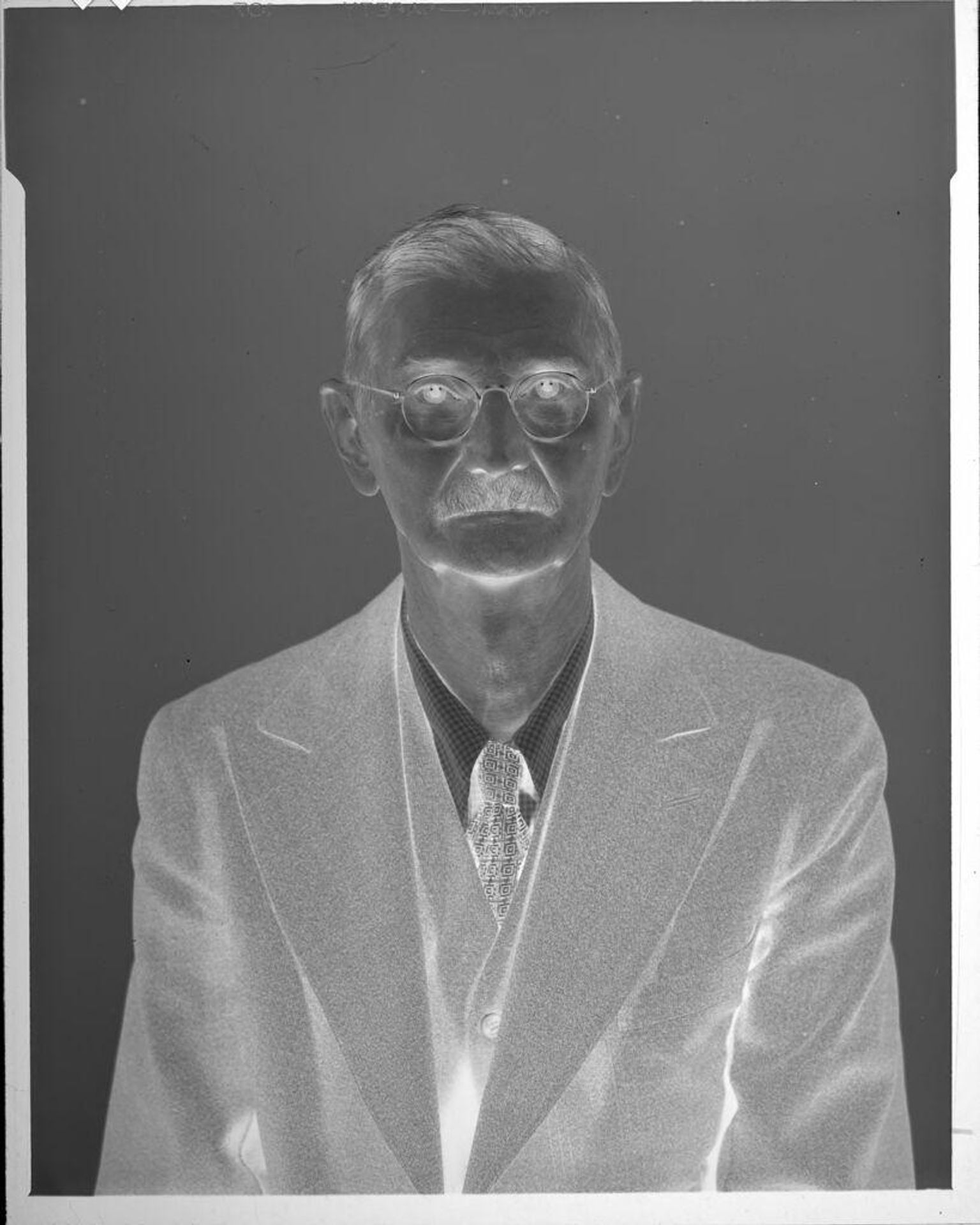 Untitled (portrait of man, wearing suit and glasses) by John Howell