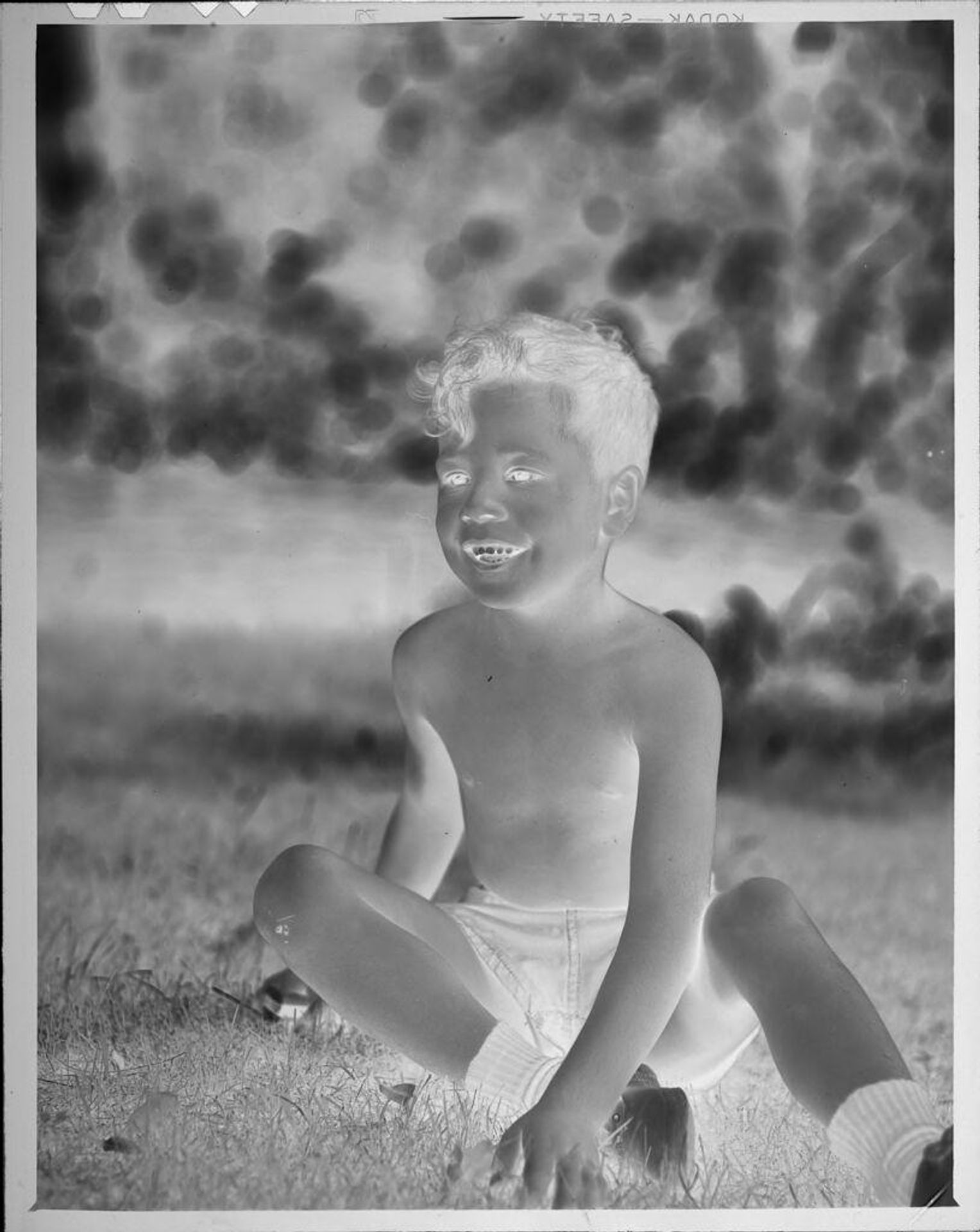 Untitled (boy sitting on grass) by Lucian and Mary Brown