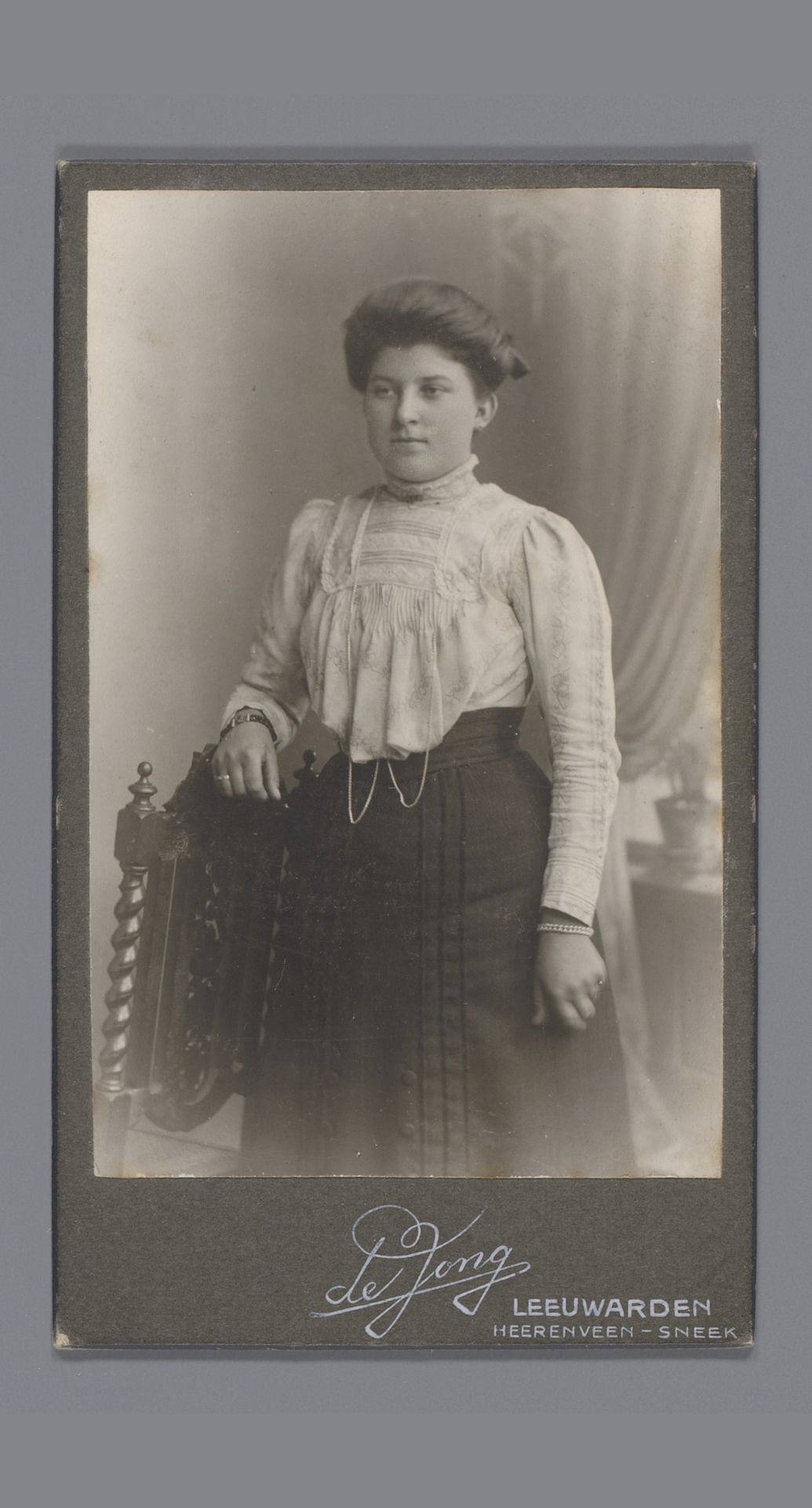 Portret van een onbekende vrouw, staande naast een stoel by Atelier de Jong