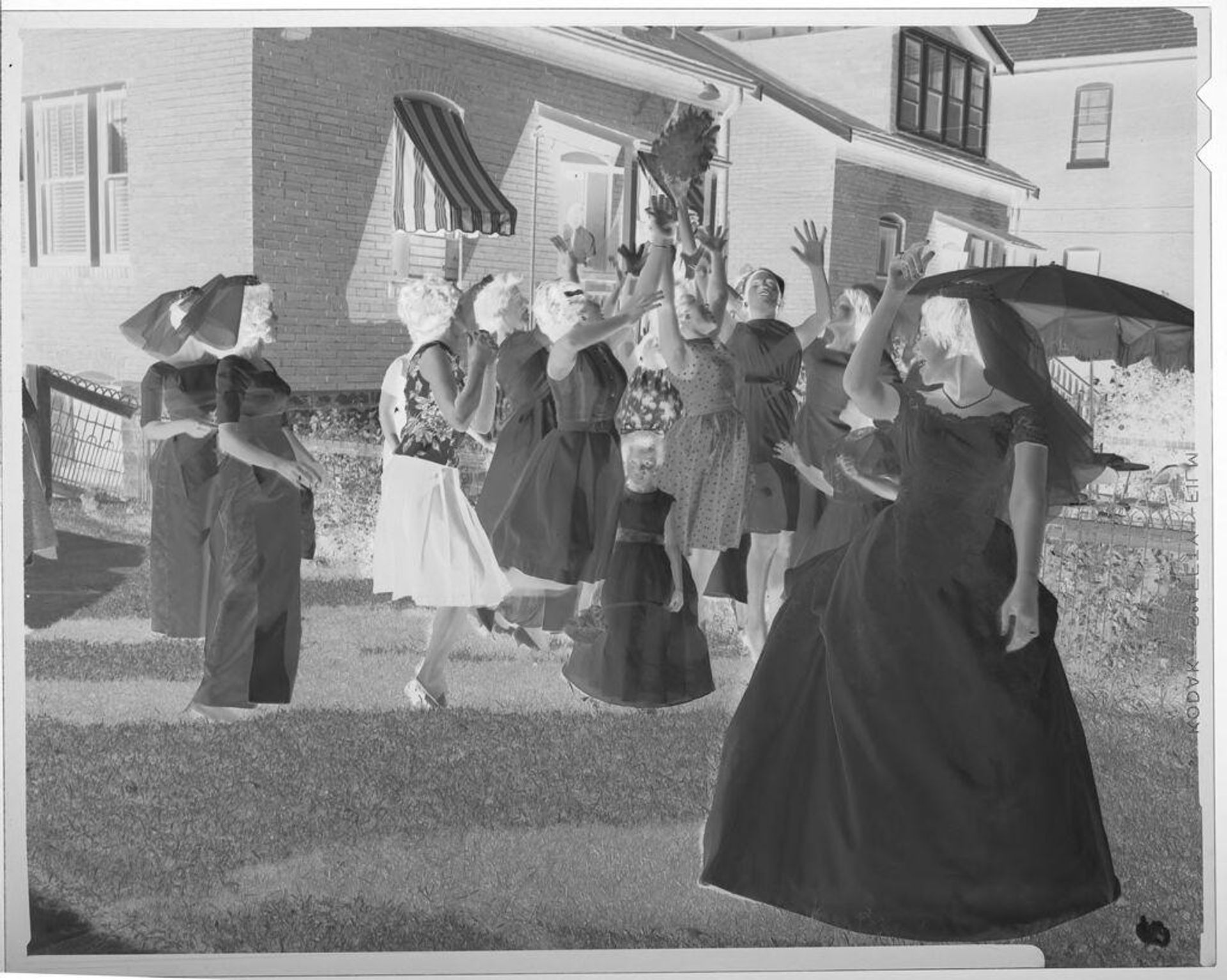 Untitled (bride throwing bouquet to women in residential yard) by Martin Schweig