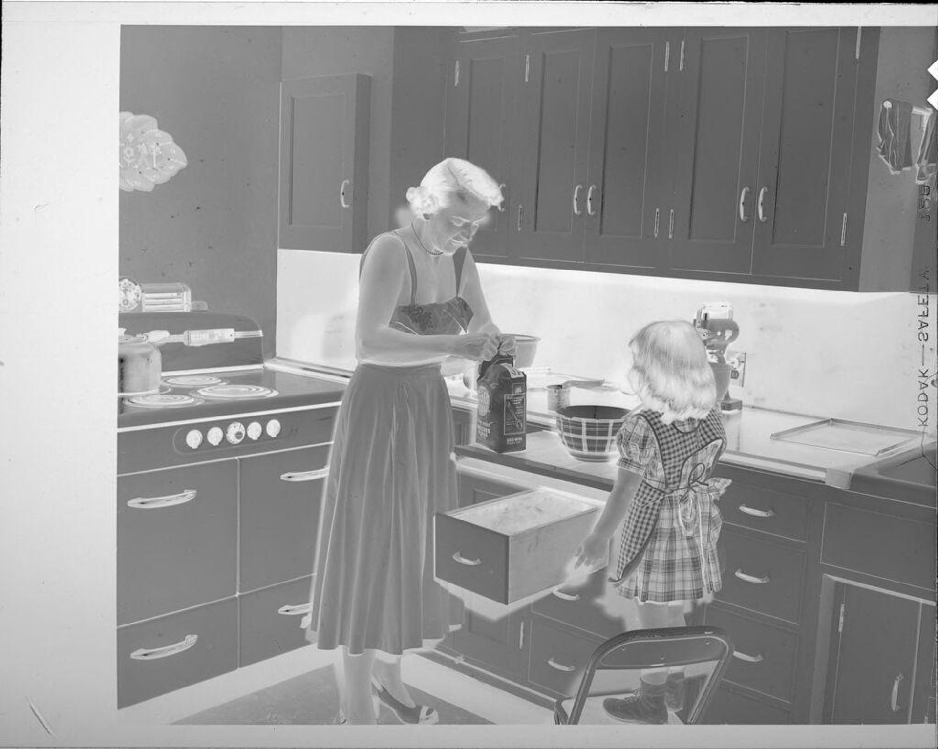 Untitled (woman and girl baking in kitchen) by Lucian and Mary Brown