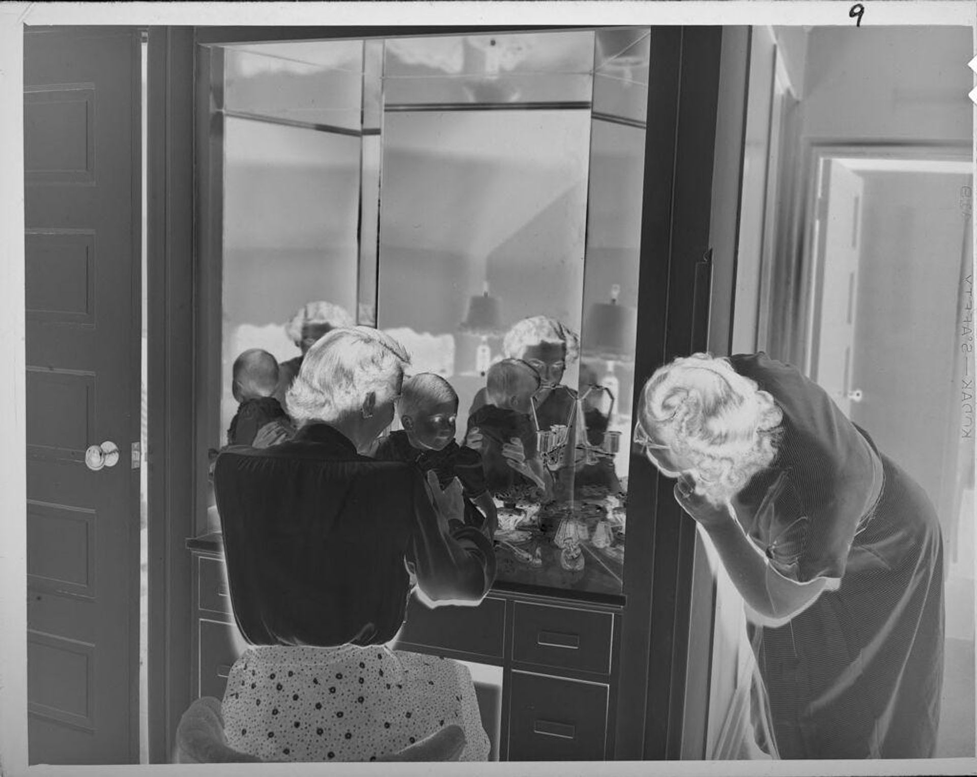 Untitled (women and baby at vanity looking into mirror) by Lucian and Mary Brown