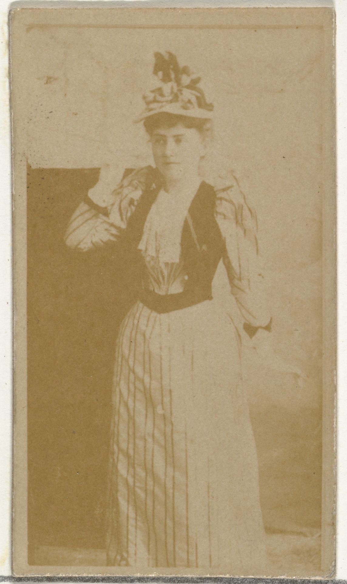 [Actress wearing dress with vertical striped pattern], from the Actors and Actresses series (N145-8) issued by Duke Sons & Co. to promote Duke Cigarettes by W. Duke, Sons & Co.