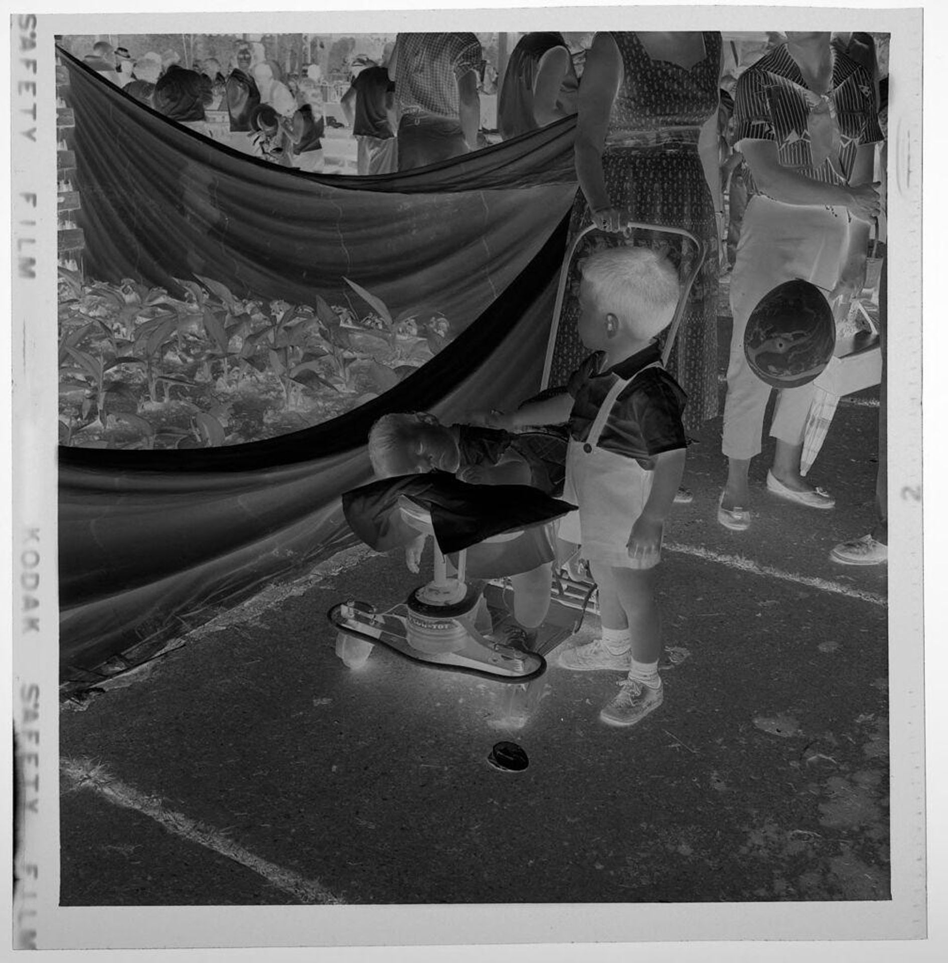 Untitled (crowd at outdoor picnic, small boy and baby in front) by Jack Gould