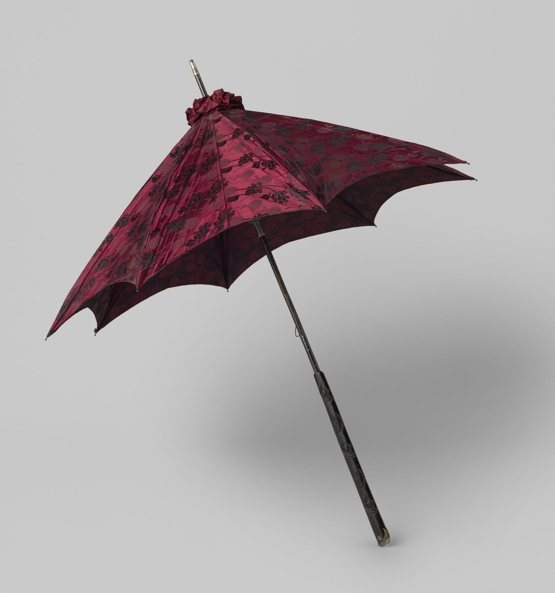 Parasol met dek van donkerrode zijde met ingeweven zwart en grijs floraal motief op een konische stok van hout waarop vijf halve manen in reliëf by Anonymous
