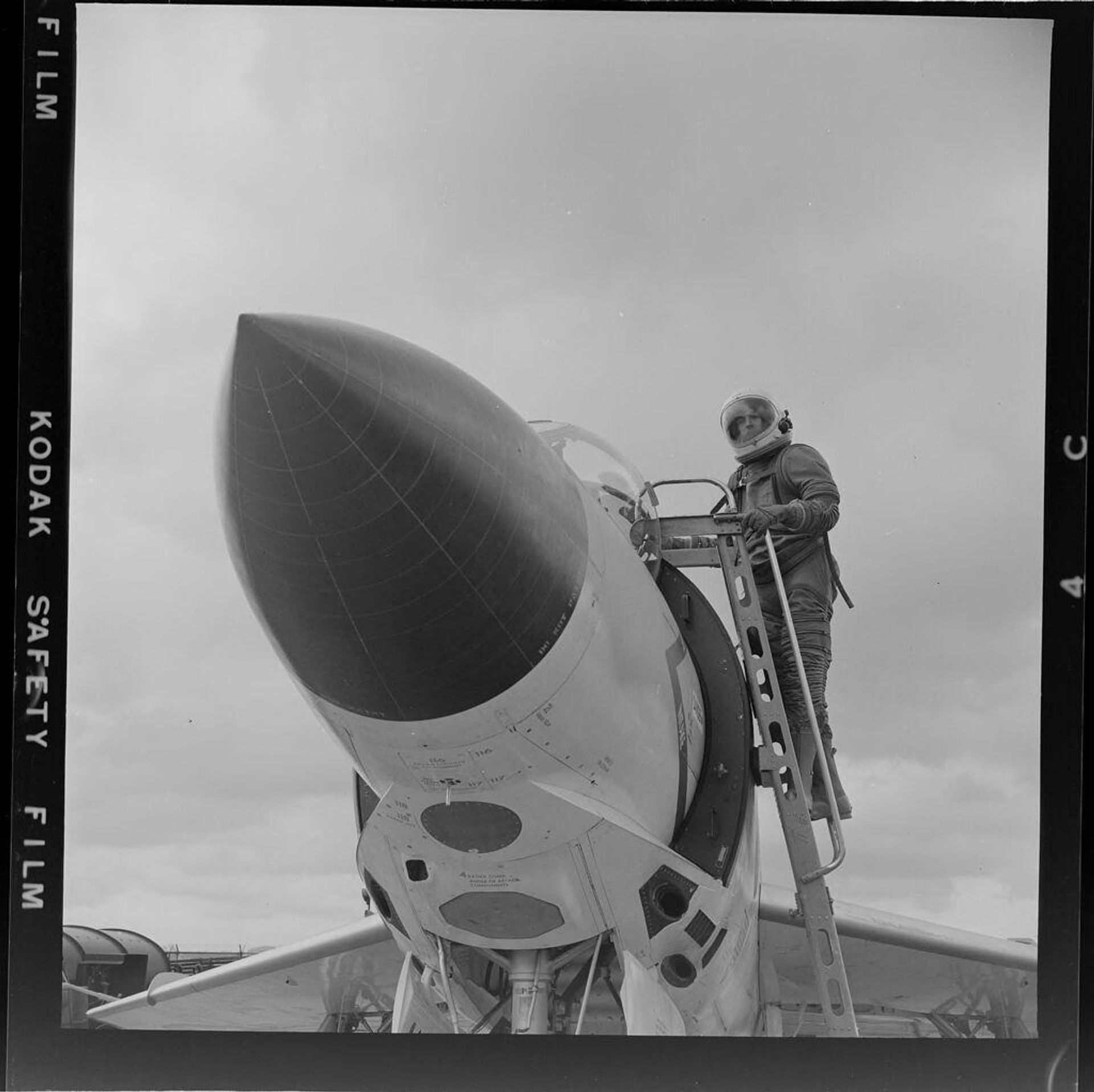 Untitled (man in pressure suit climbing into jet) by Jack Gould