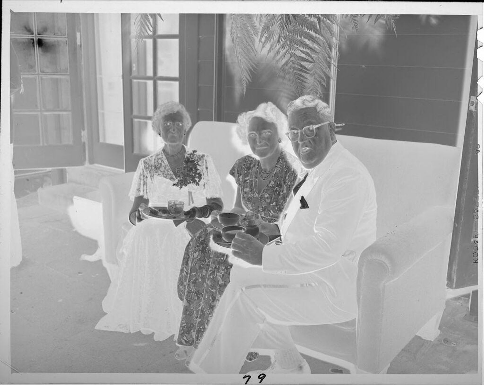 Untitled (man and two women on couch drinking coffee) by Lucian and Mary Brown