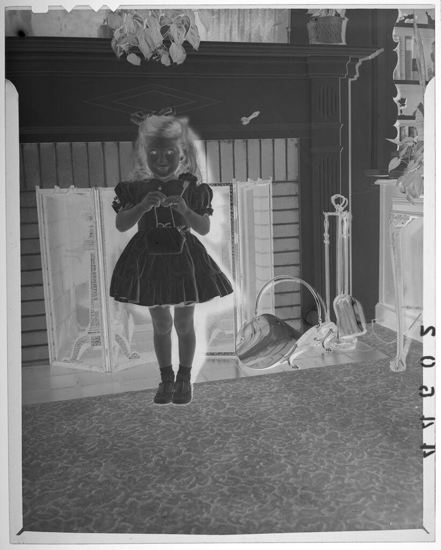 Untitled (young girl posed holding purse in front of fireplace) by Martin Schweig