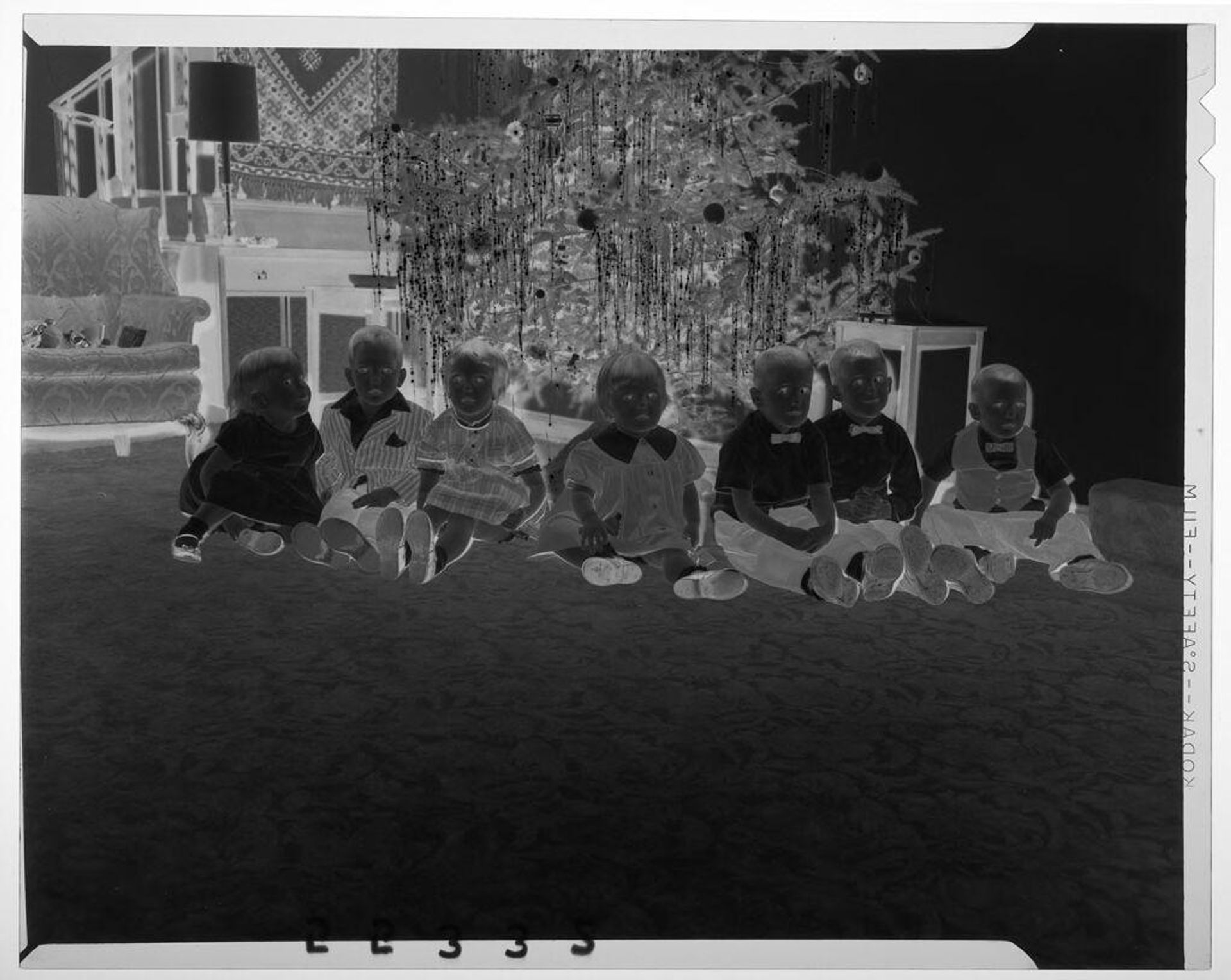 Untitled (seven young children posed sitting in front of Christmas tree) by Martin Schweig