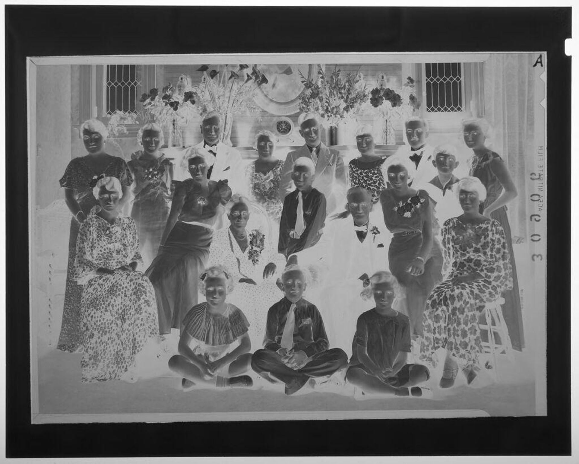 Untitled (large group portrait of nineteen member family in formal wear posing in front of mantel) by Martin Schweig