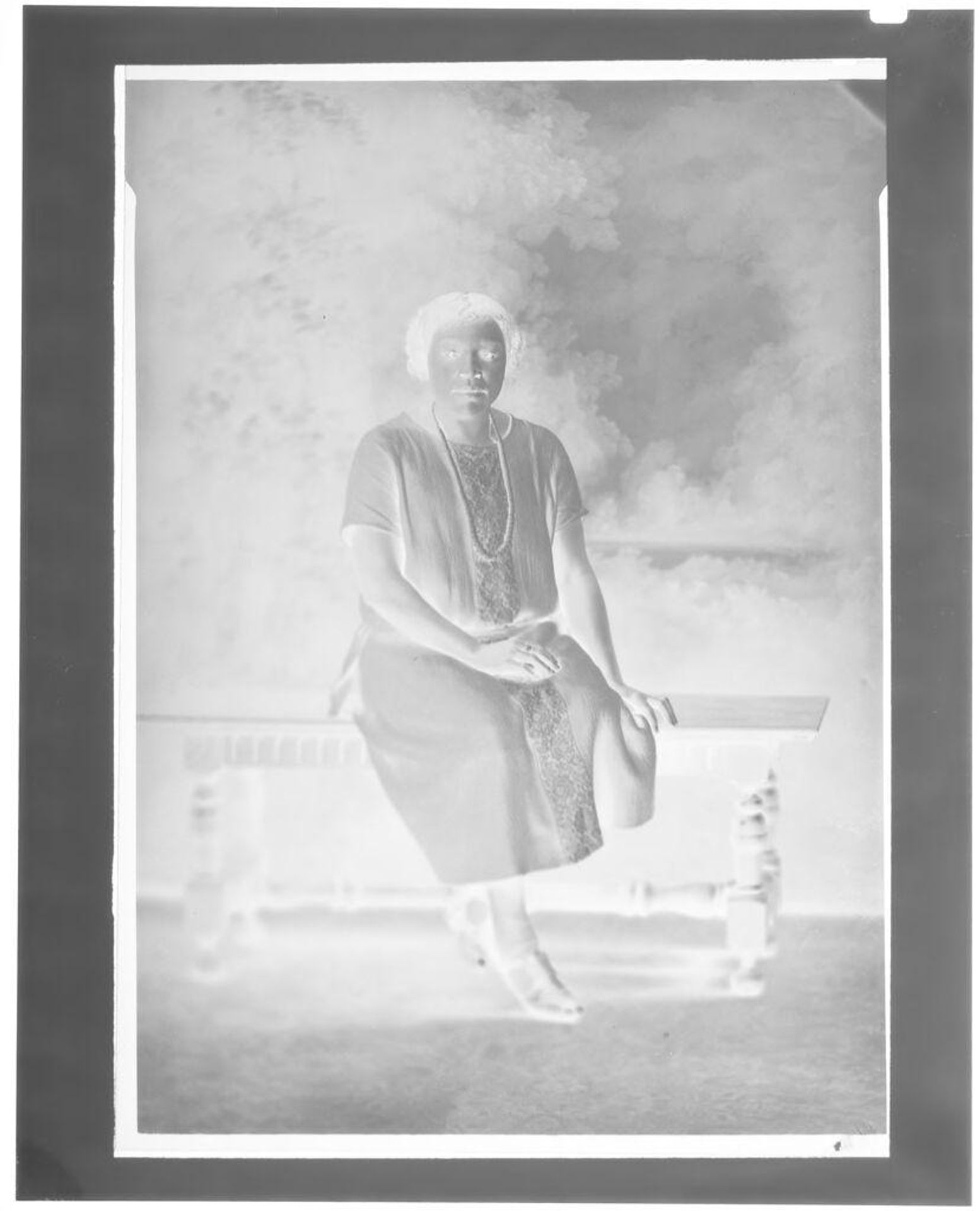 Untitled (portrait of a woman seated on a bench in studio) by Hamblin Studio