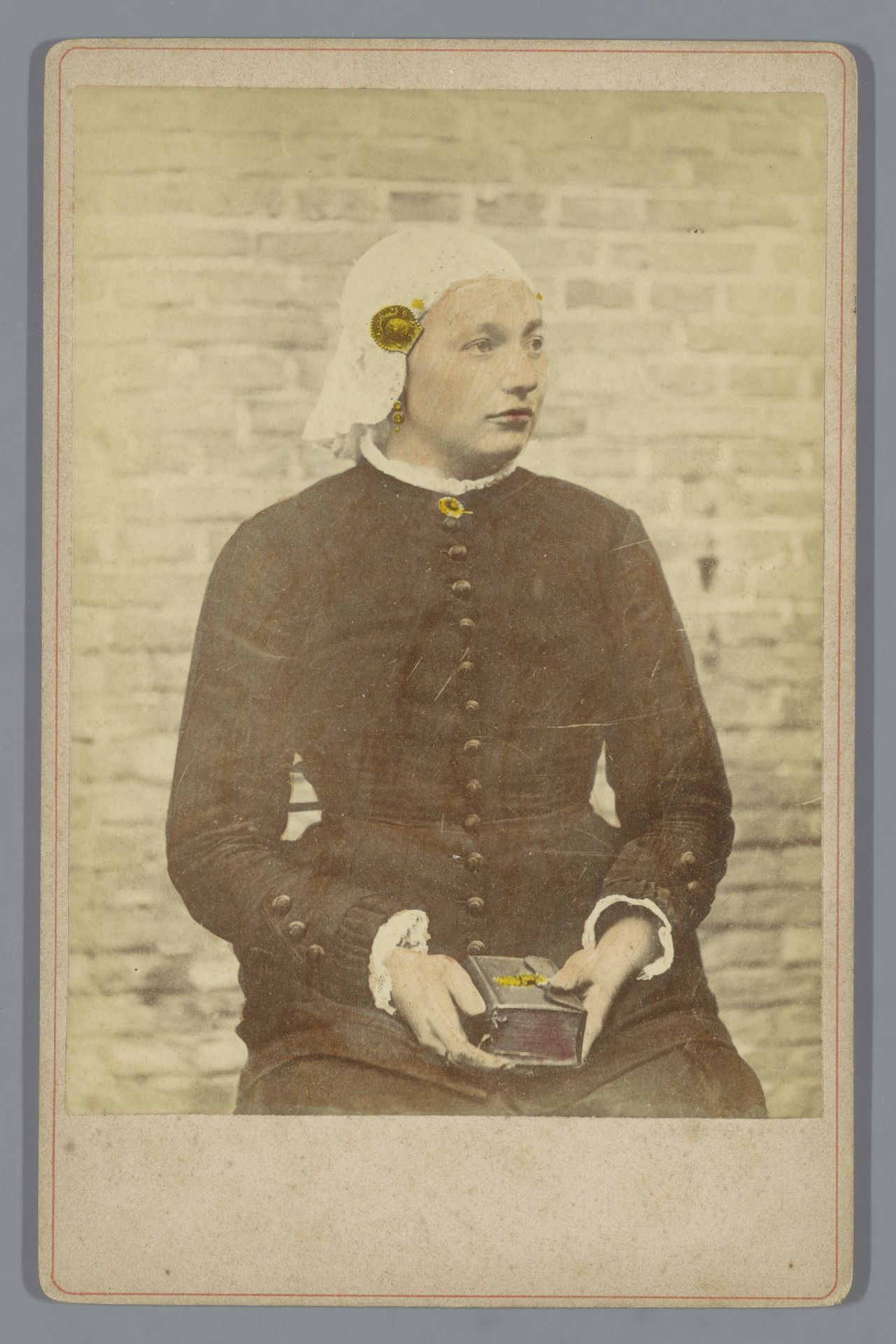 Portret van een onbekende vrouw in klederdracht van Leeuwarden en een boek op haar schoot by Anonymous