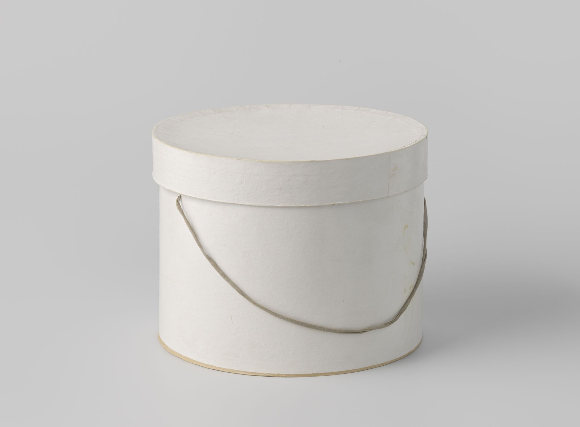 Ronde hoedendoos met deksel, van karton beplakt met roomkleurig papier by Tim Bönig