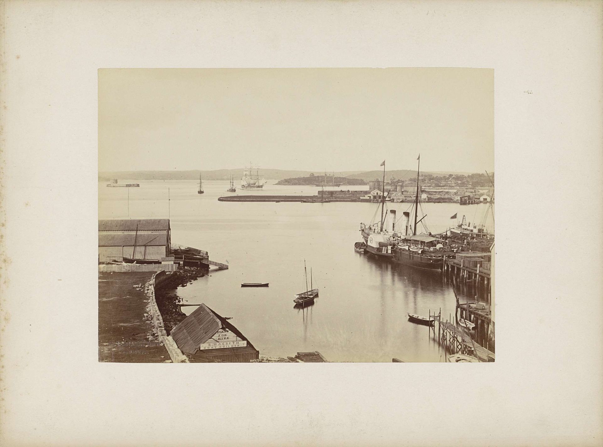 Gezicht op een haven met op de voorgrond het botenverhuur- en scheepsbouwbedrijf van B. Macbeth, vermoedelijk in Sydney by Charles Bayliss