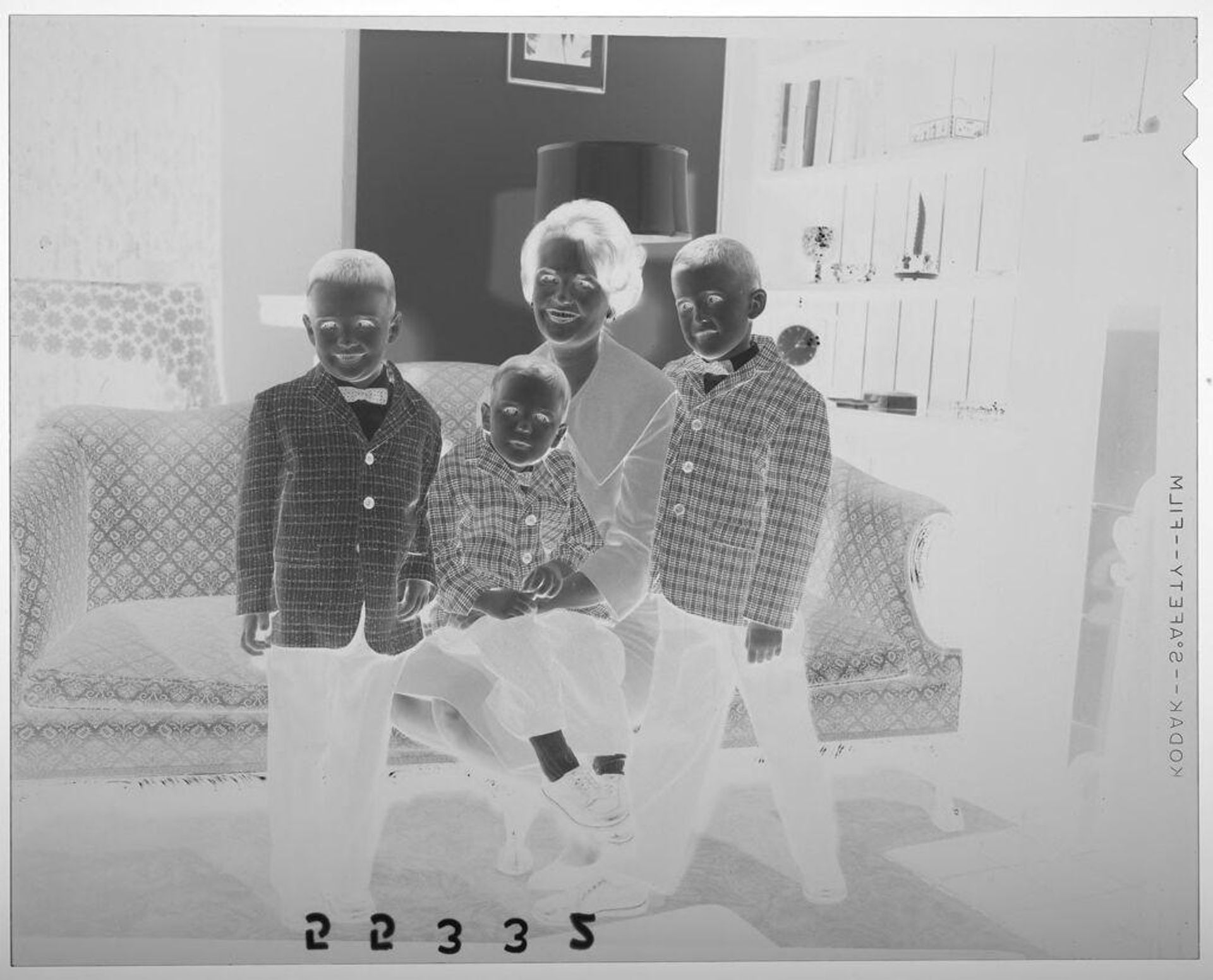 Untitled (woman posed with three young sons on couch at Christmas gathering) by Martin Schweig