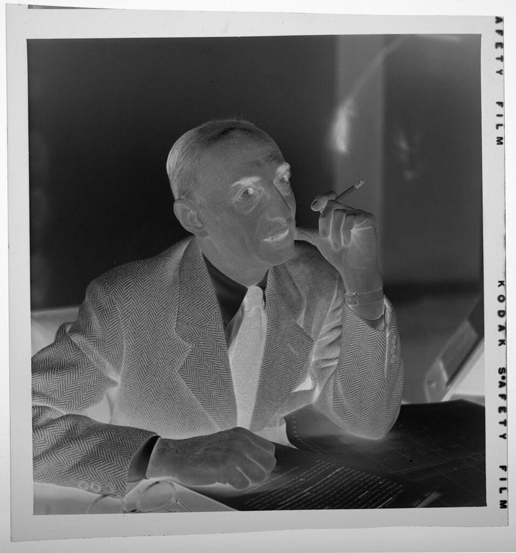 Untitled (man seated at table smoking cigarette) by Jack Gould