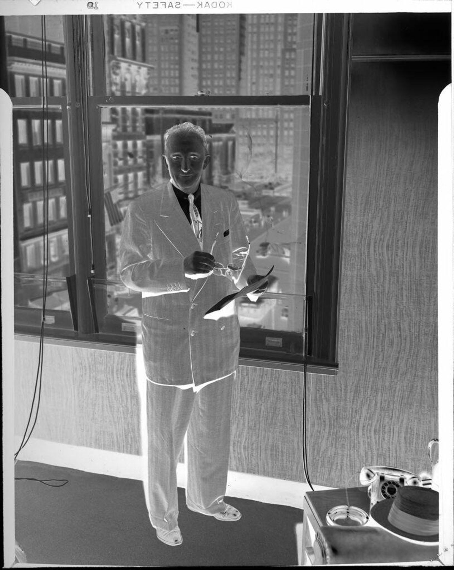 Untitled (man standing in front of window) by Peter James Studio
