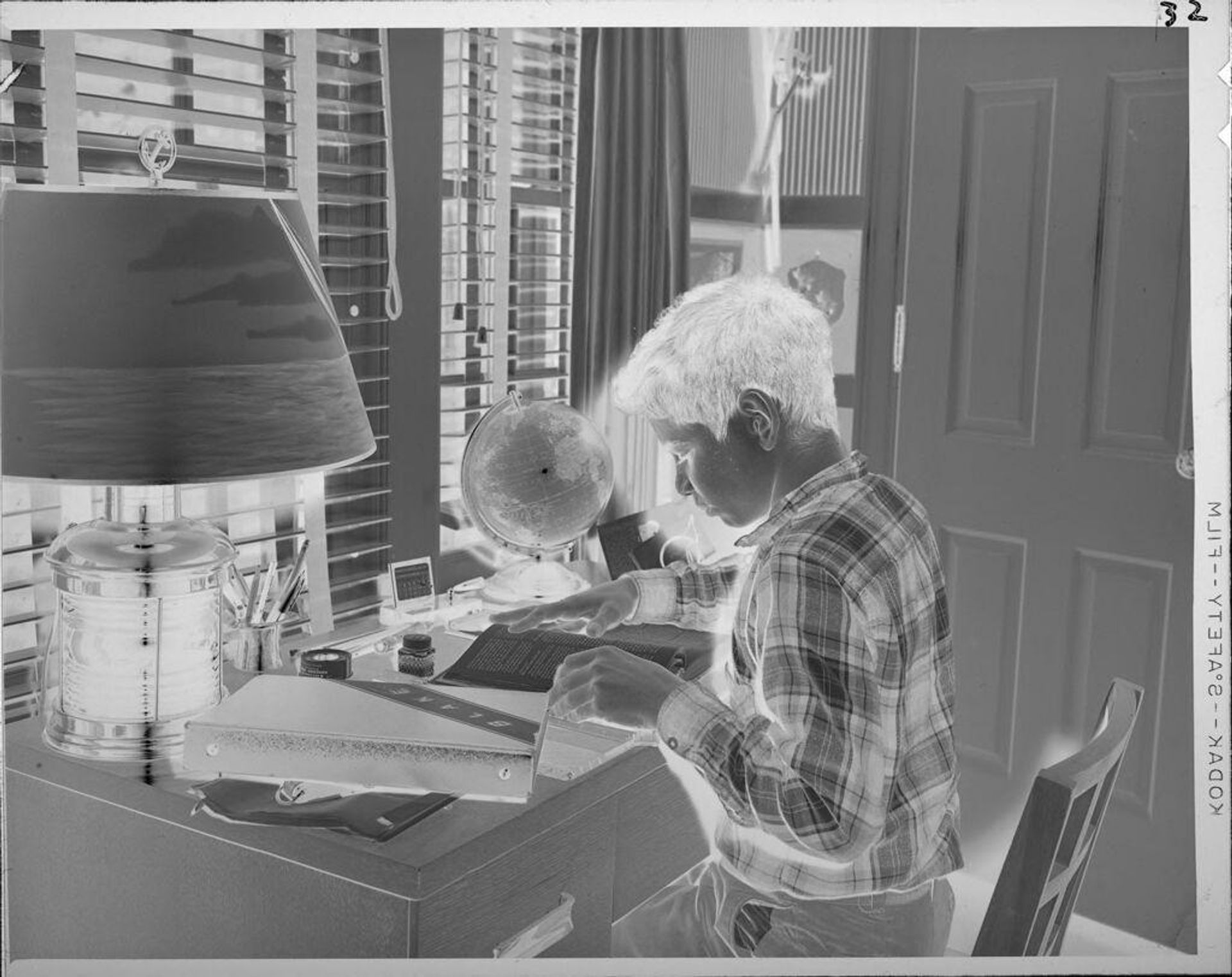 Untitled (boy reading book at desk) by Lucian and Mary Brown