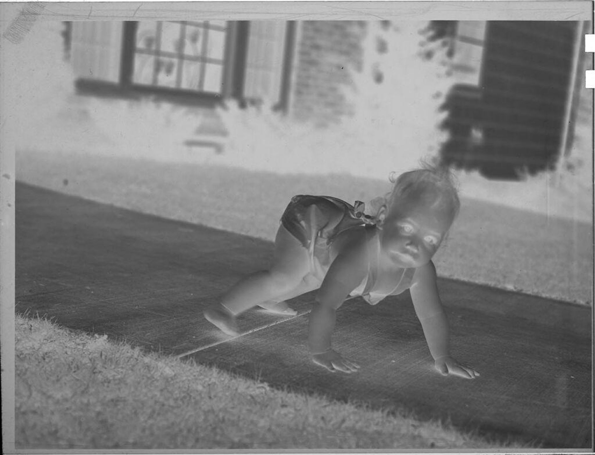 Untitled (baby crawling on sidewalk) by Lucian and Mary Brown