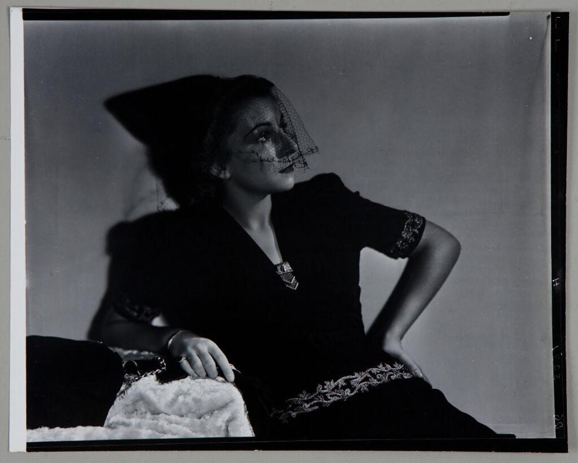 Untitled (woman in veiled hat leaning back on elbow, looking off to right) by Paul Gittings