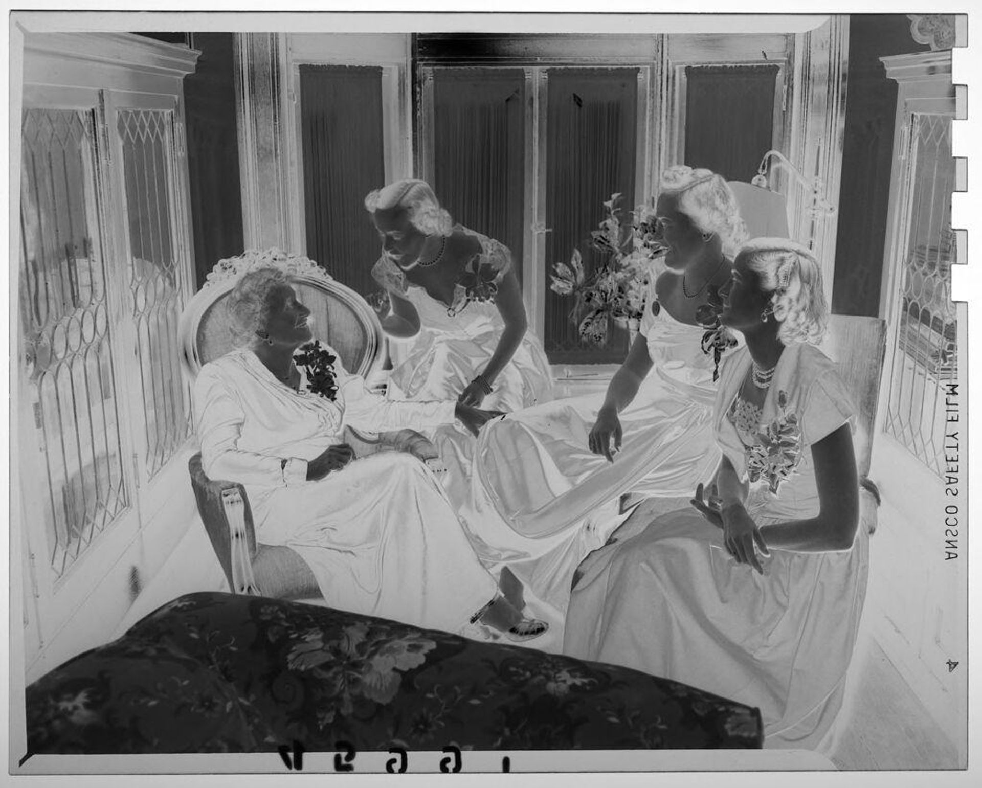 Untitled (three young women in formal dresses posed chatting with middle-aged woman in chair) by Martin Schweig