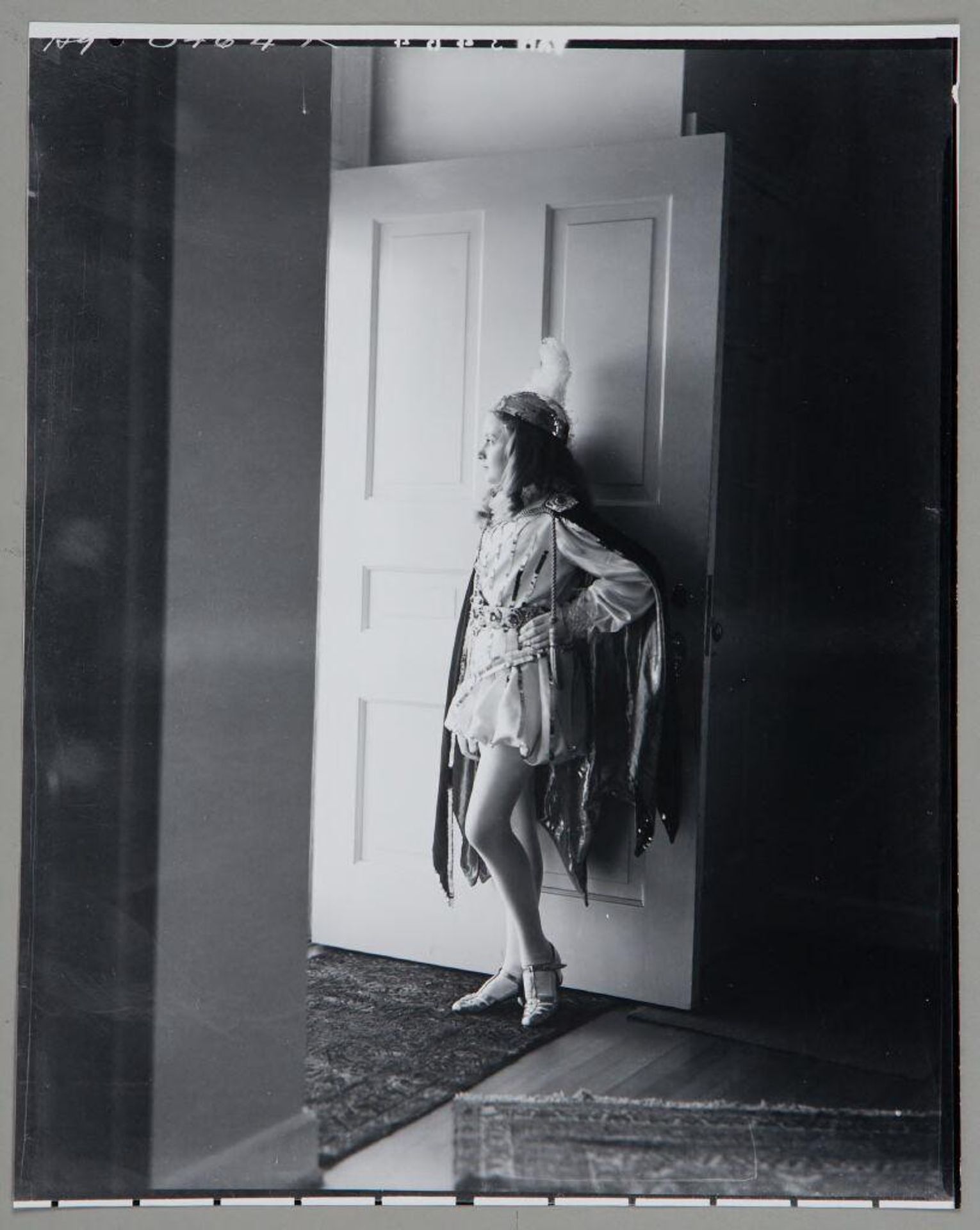 Untitled (girl in performance costume and feather headdress standing in doorway) by Paul Gittings