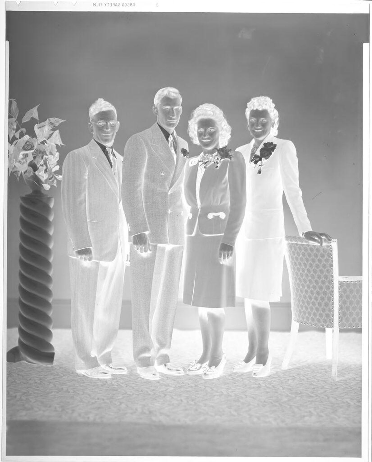 Untitled (two men and two women posed in suits in studio) by John Deusing