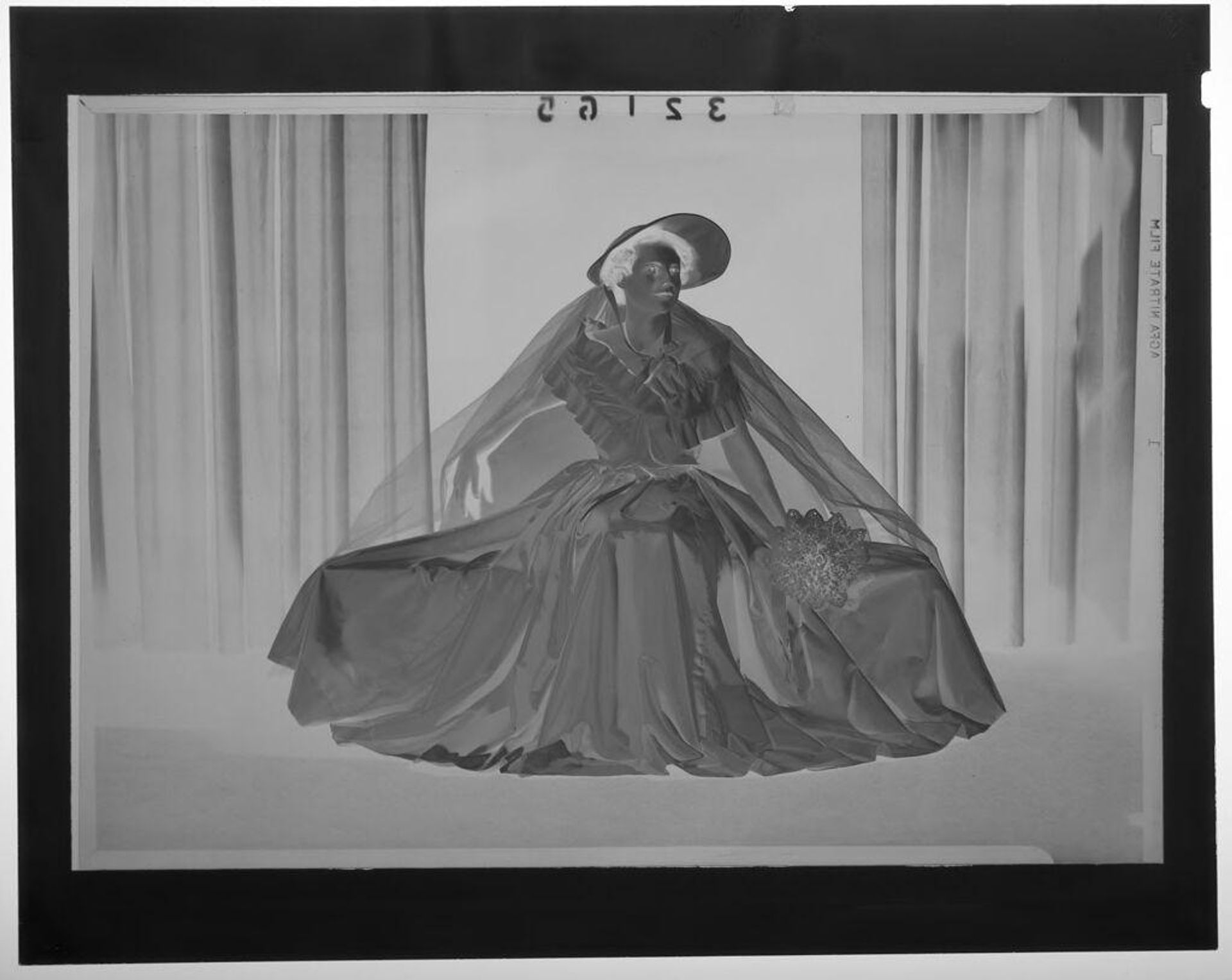 Untitled (studio portrait of woman in off-shoulder dress and bonnet with veil) by Martin Schweig