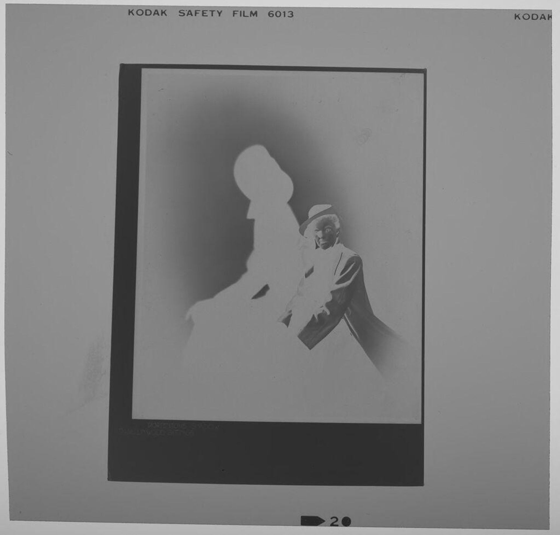 Untitled (photograph of "Portentous Shadow": figure seated in hat with large shadow) by Paul Gittings