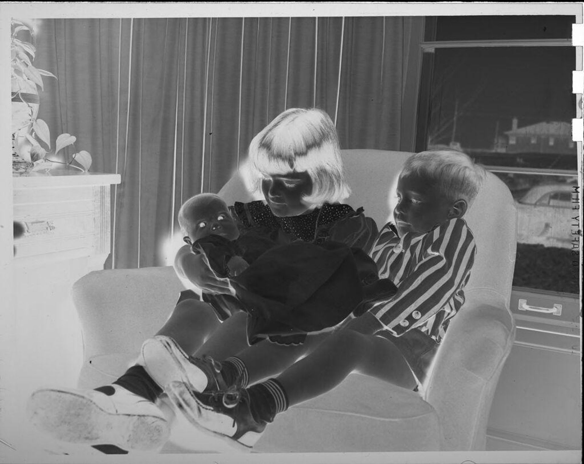 Untitled (girl, boy, and baby on chair) by Lucian and Mary Brown