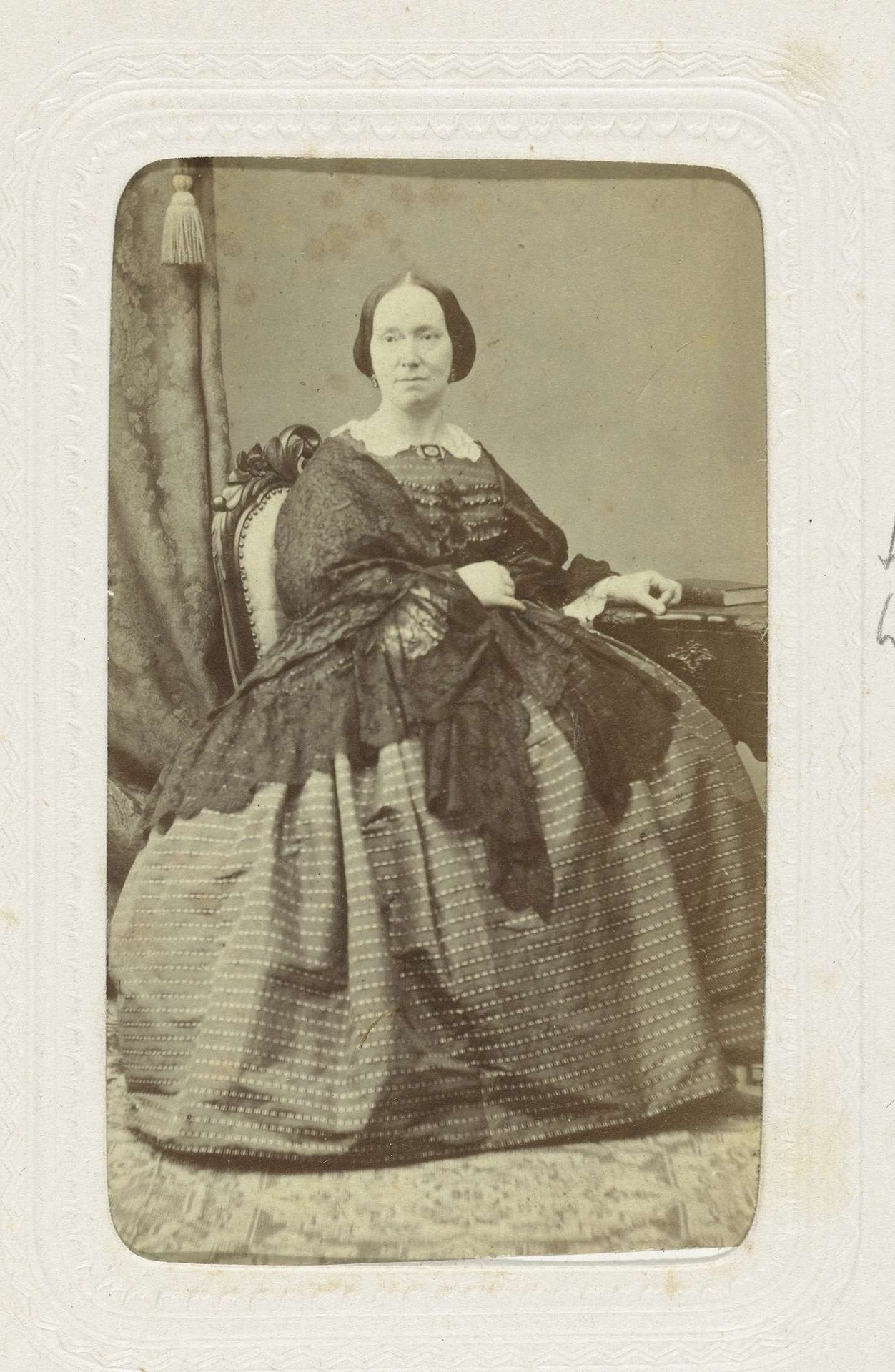 Studioportret van een vrouw in een bolle jurk, zij zit aan een dressoir by Heinrich Löwenstein