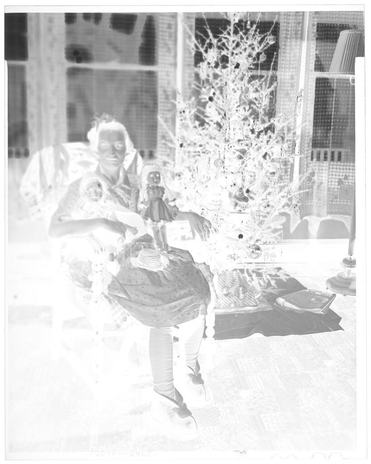 Untitled (woman seated in chair with dolls by Christmas tree) by John Deusing