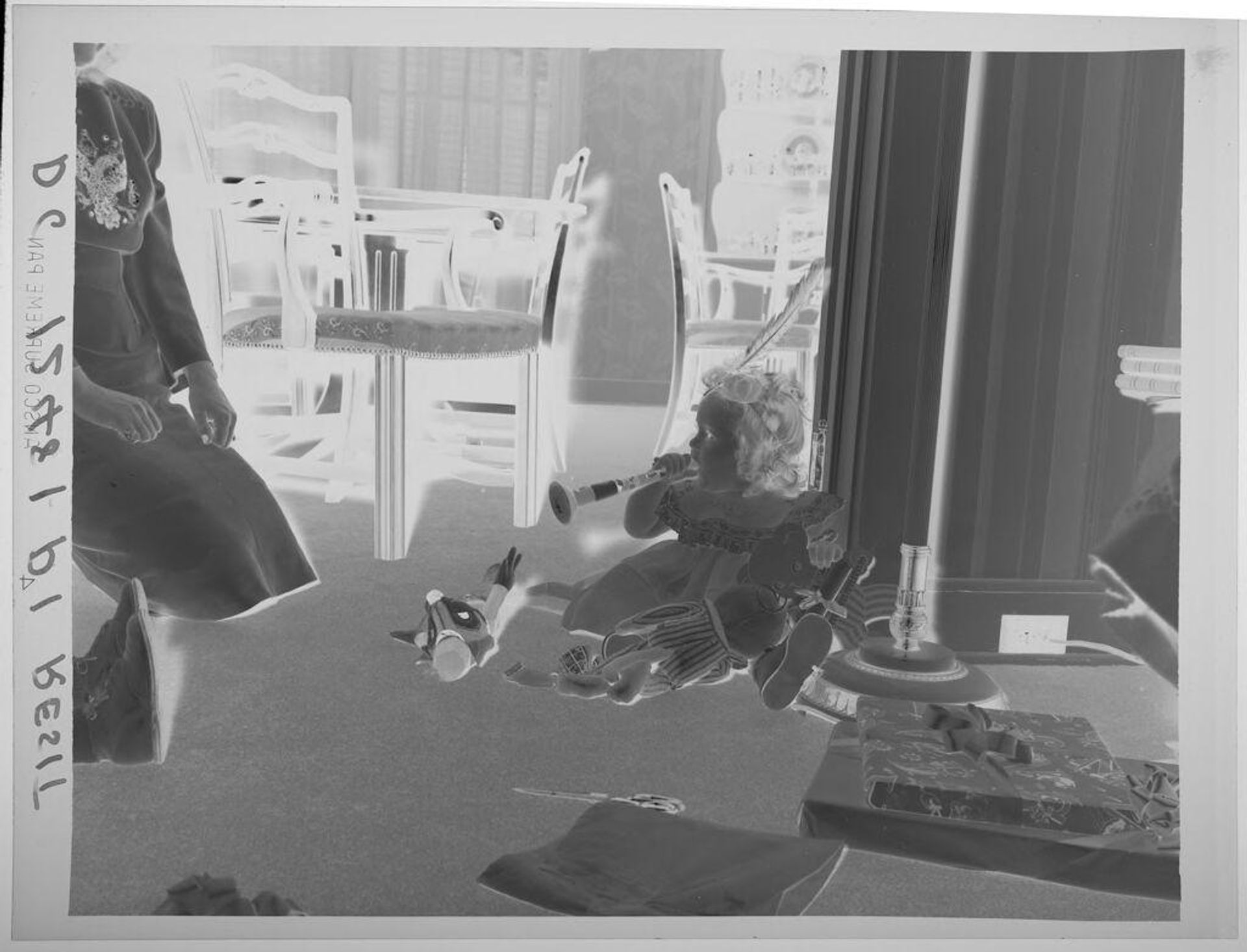 Untitled (little girl on her first birthday with open and wrapped presents, feather in hair) by Paul Gittings