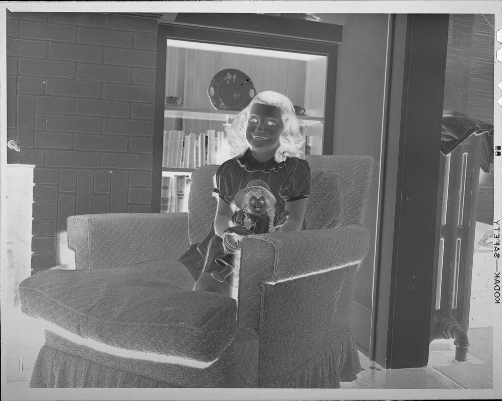 Untitled (girl in armchair with doll) by Lucian and Mary Brown