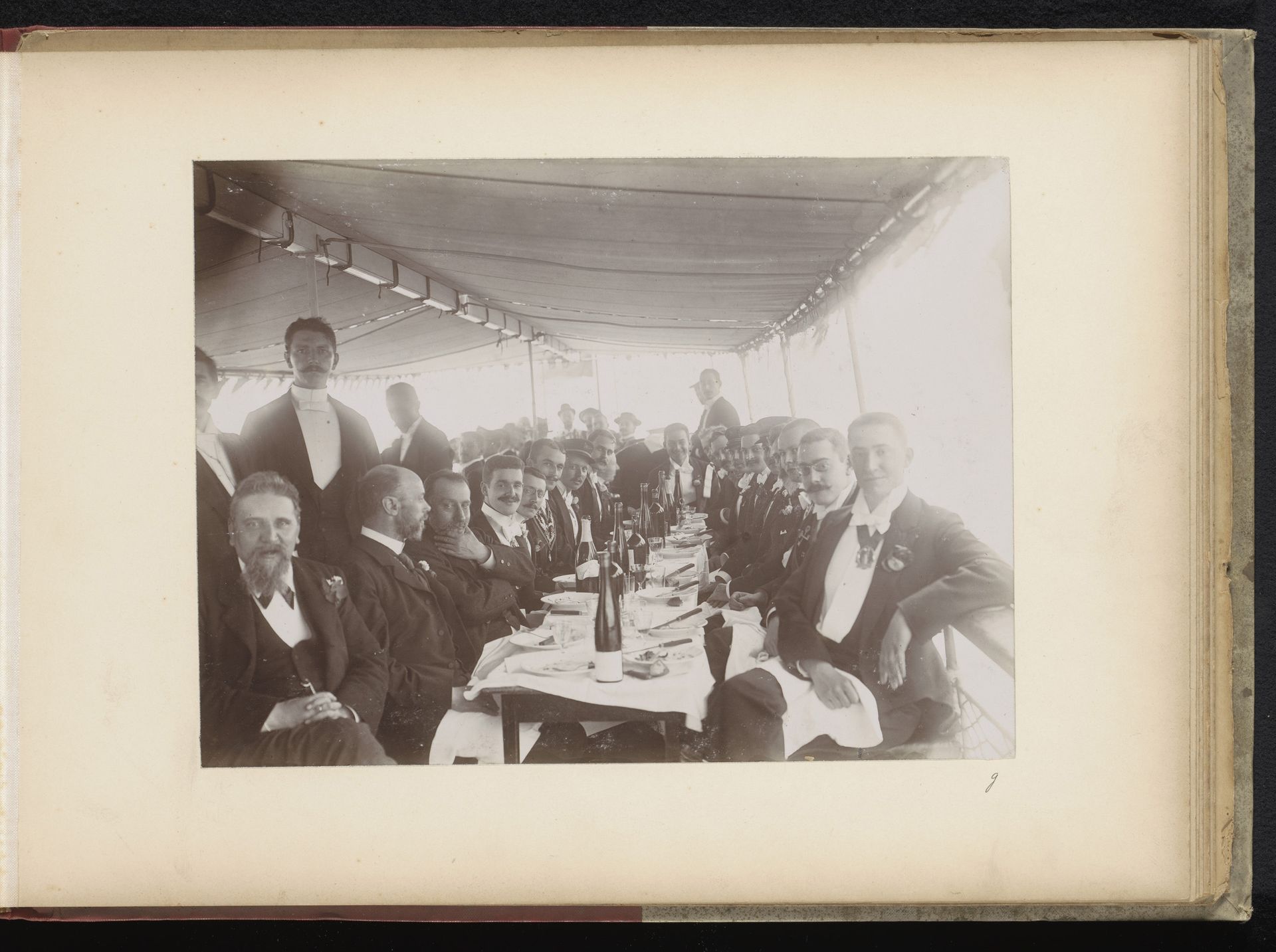 Groep leden van het Amsterdamsch Studenten Corps aan tafel op een rondvaartboot by Nicolaas Schuitvlot