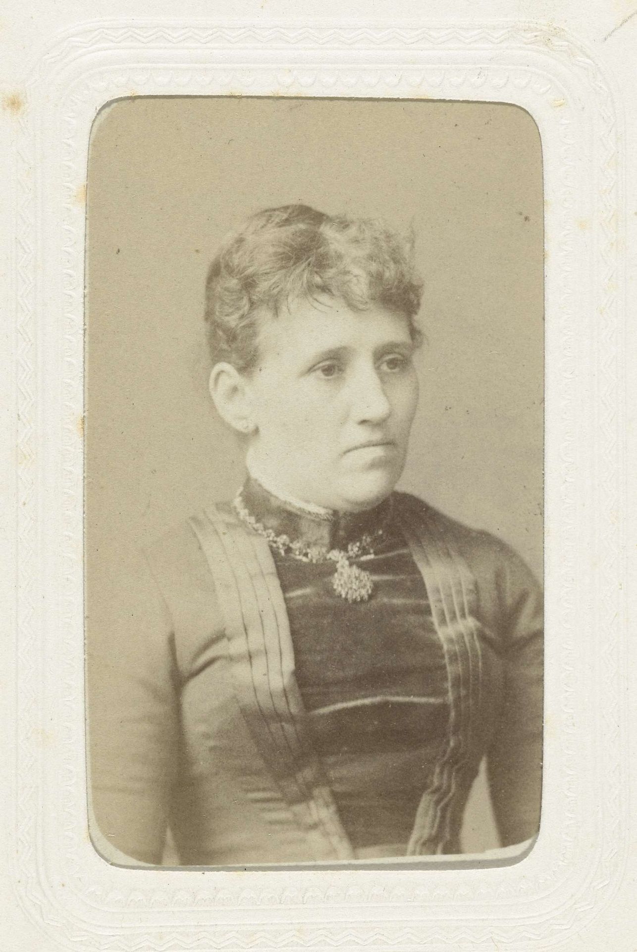 Studioportret van een vrouw gekleed in een nauwsluitend bovenstuk by Albert Greiner
