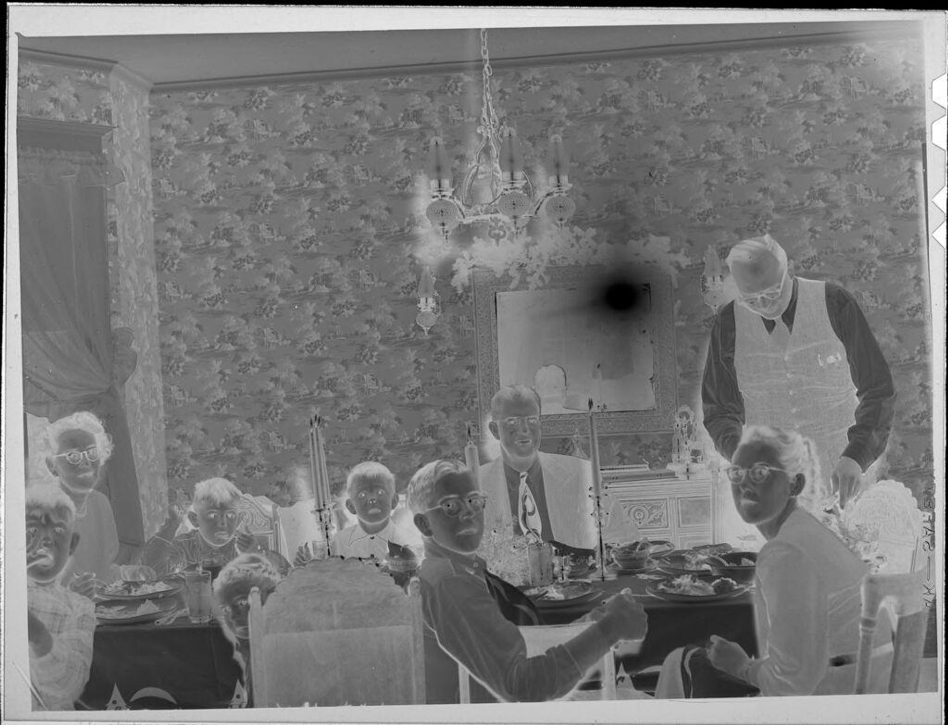 Untitled (family eating at dining room table) by Lucian and Mary Brown