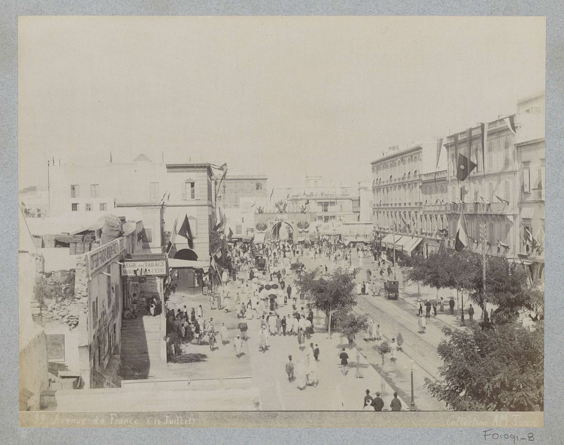 Gezicht op de Avenue de France in Tunis met stadspoort, winkels en voorbijgangers op 14 juli (quatorze juillet) by AM