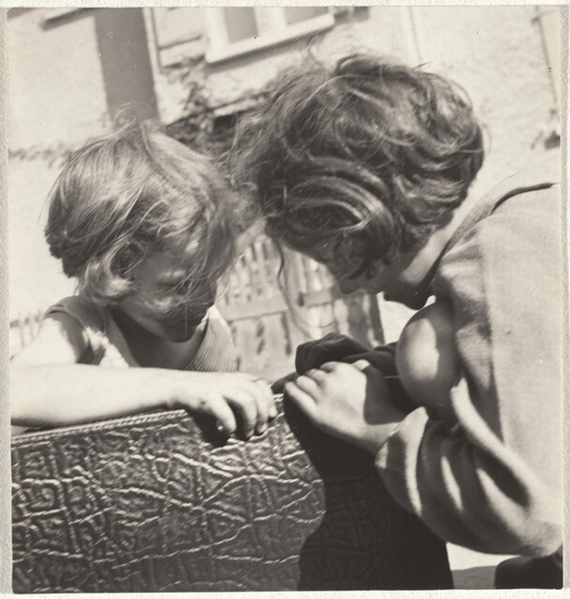 Children playing with suitcase by Robert Frank