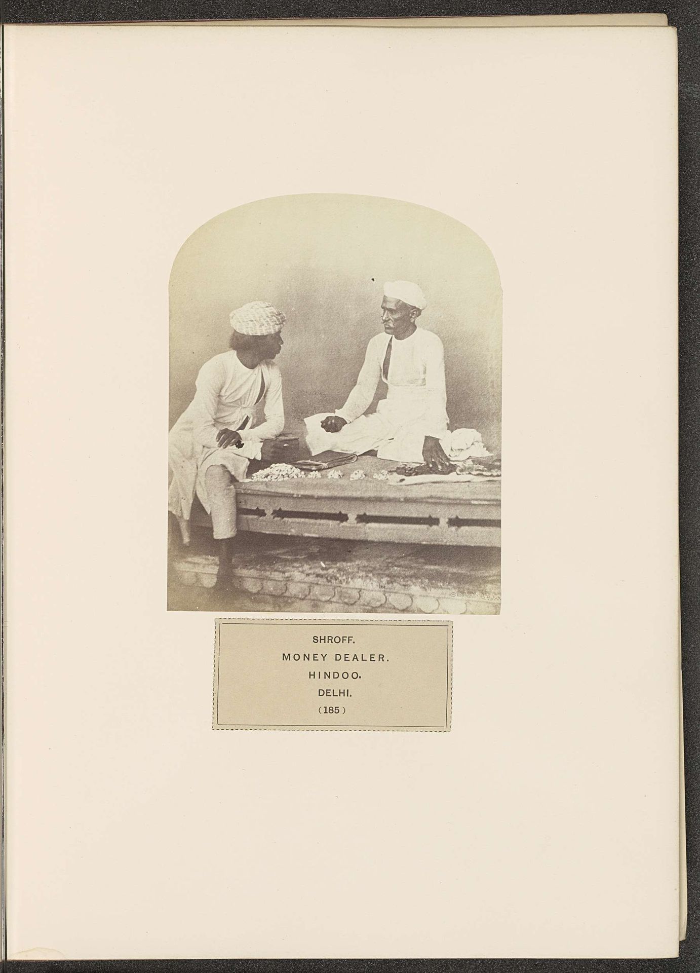 Geldwisselaar met een man voor zijn handel in Delhi by Shepherd & Robertson