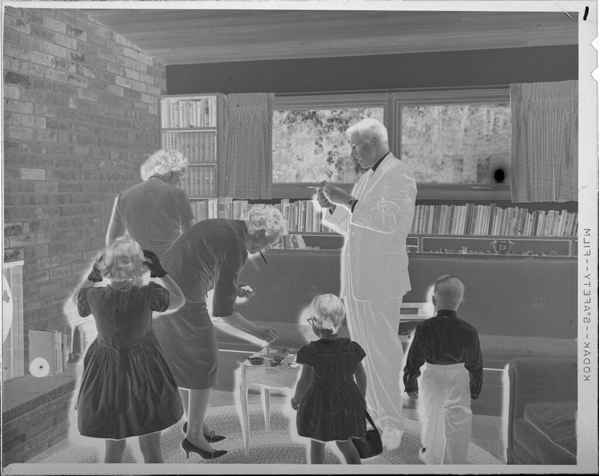 Untitled (adults and children in living room) by Lucian and Mary Brown