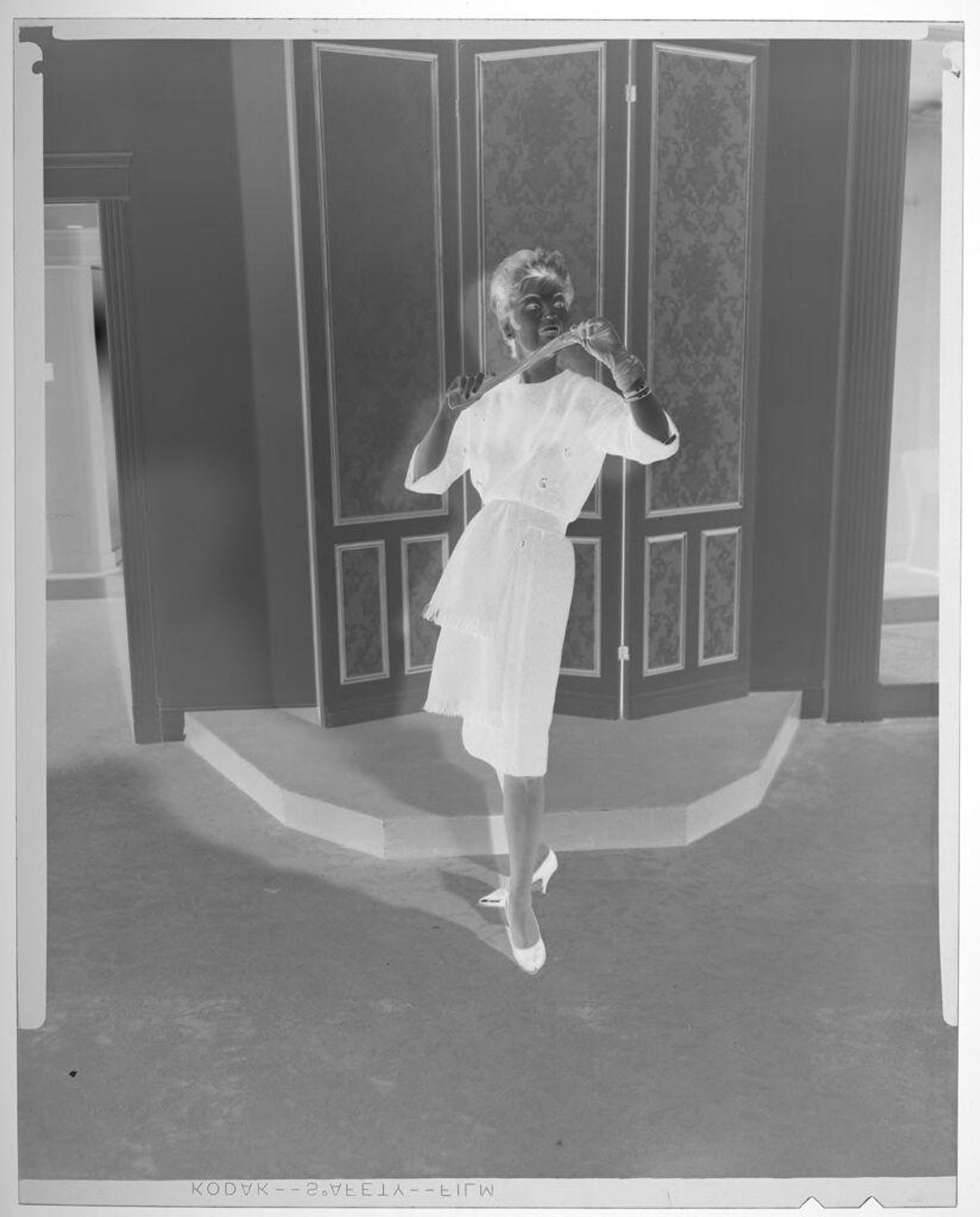 Untitled (fashion portrait of woman in dark coat holding glove in stylized pose) by Martin Schweig