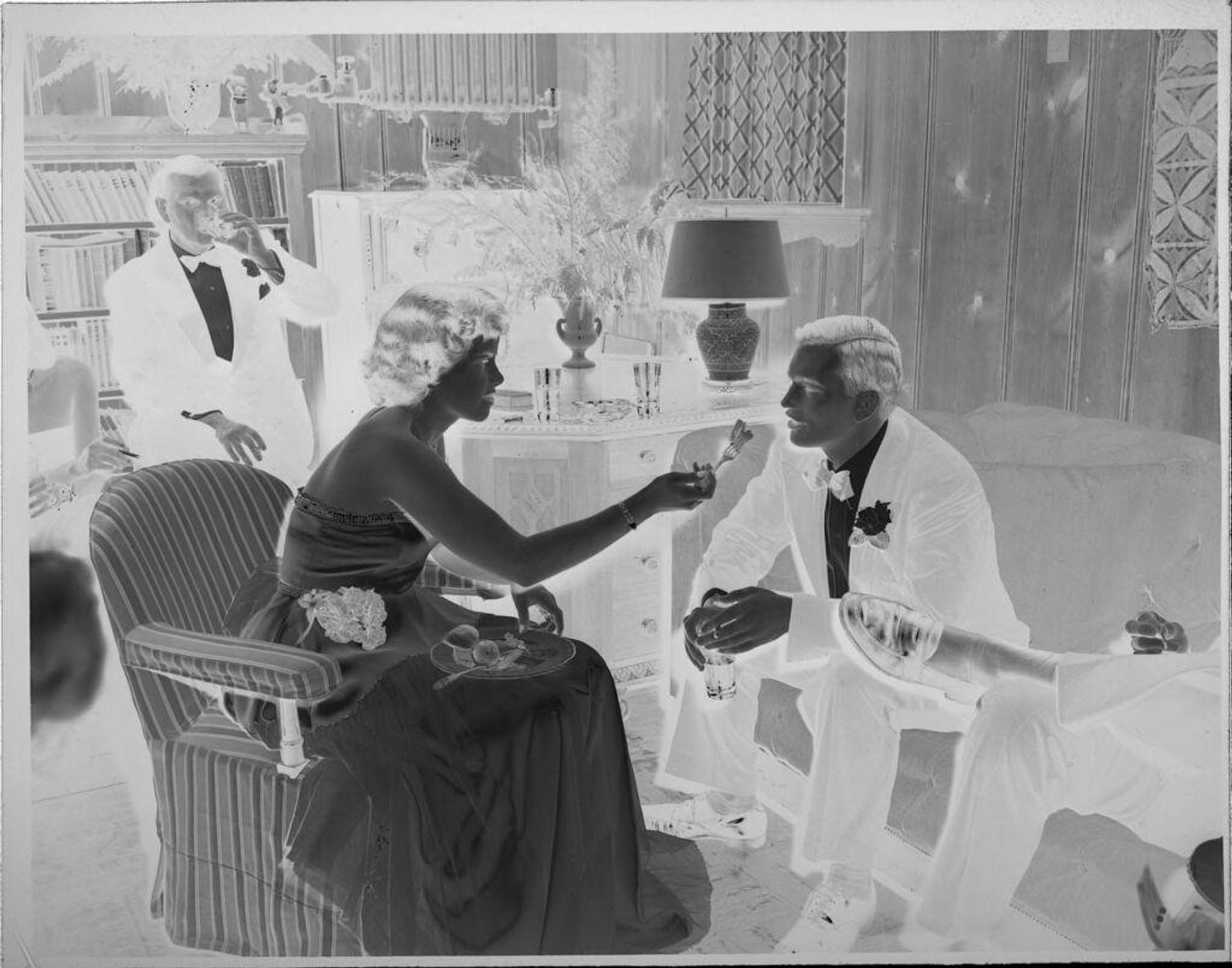 Untitled (people at party, woman feeding man) by Lucian and Mary Brown