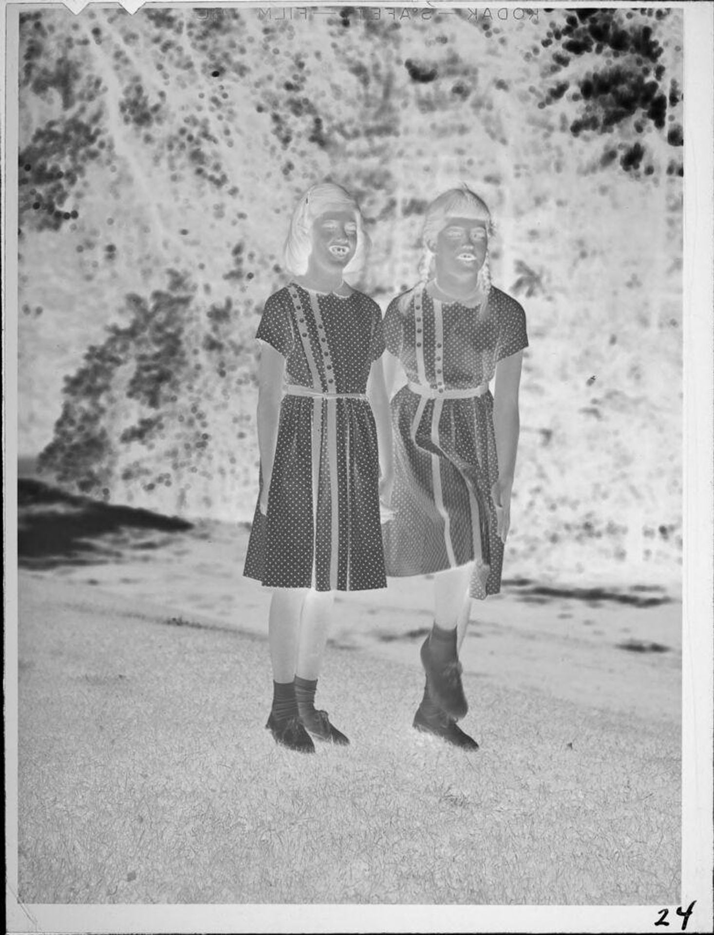 Untitled (two girls in matching dresses standing outside) by Lucian and Mary Brown