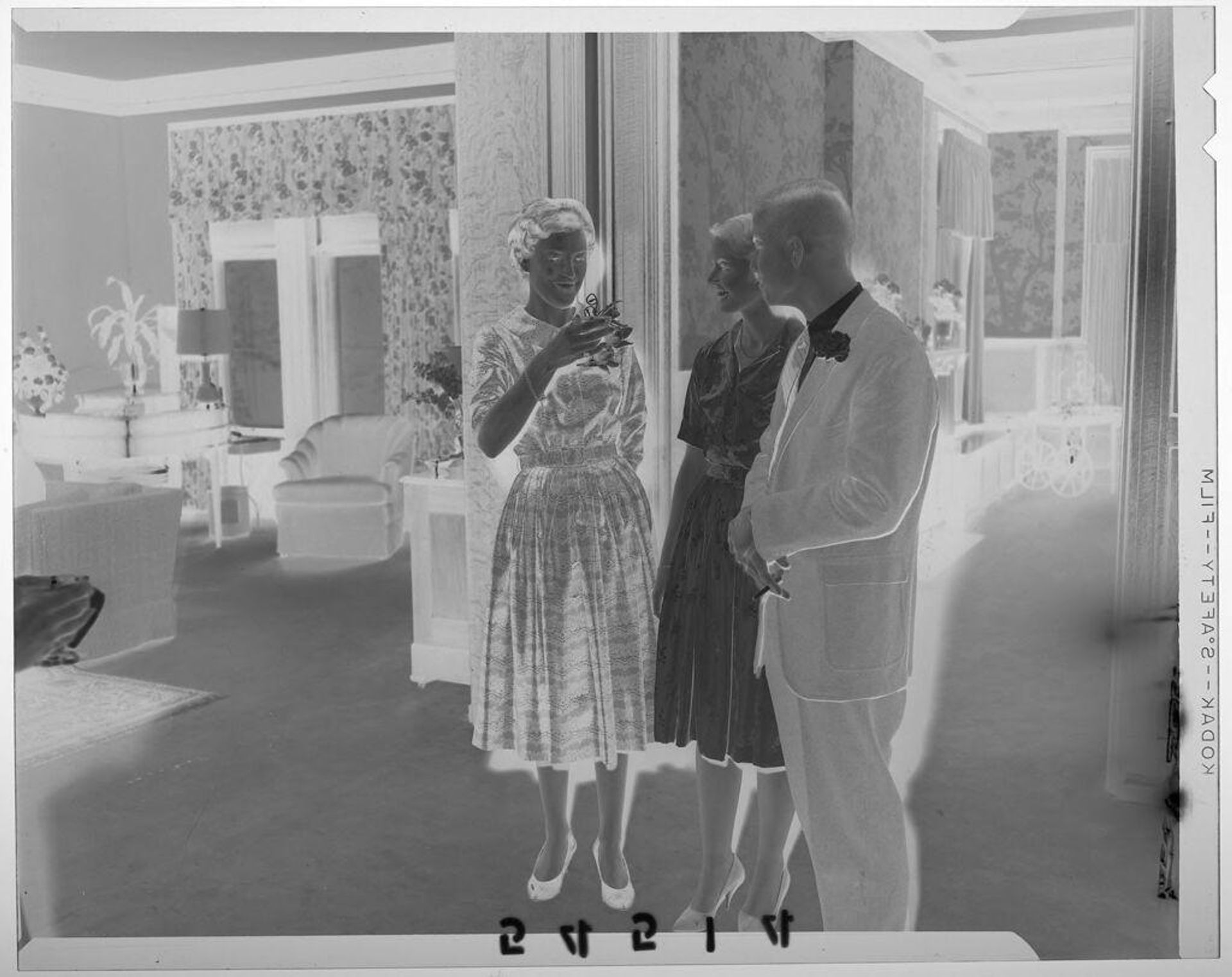 Untitled (young couple chatting with woman between two rooms in family home) by Martin Schweig