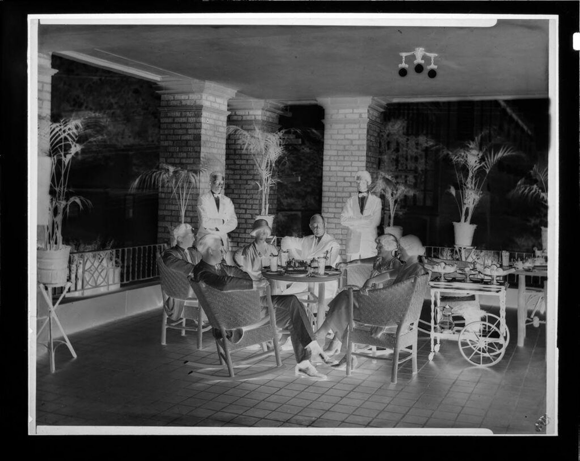 Untitled (people dining at table on veranda) by Hamblin Studio